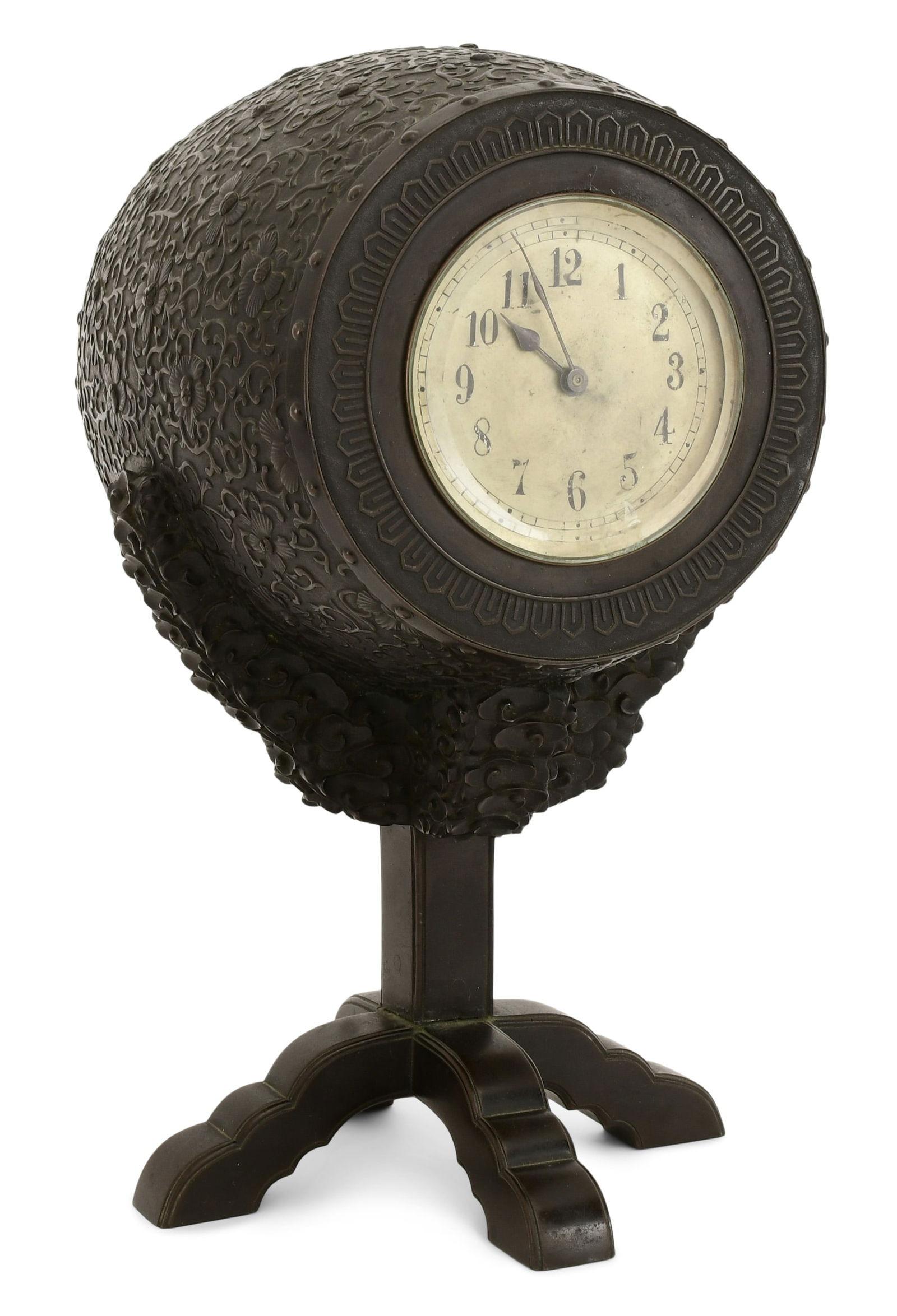 Very unique antique (late 19th to early 20th century) table or mantel clock in the Japonisme style, possibly of continental origin, in the form of a Japanese drum or barrel on stand, exceptionally modeled and cast with repeating flowering vine motif