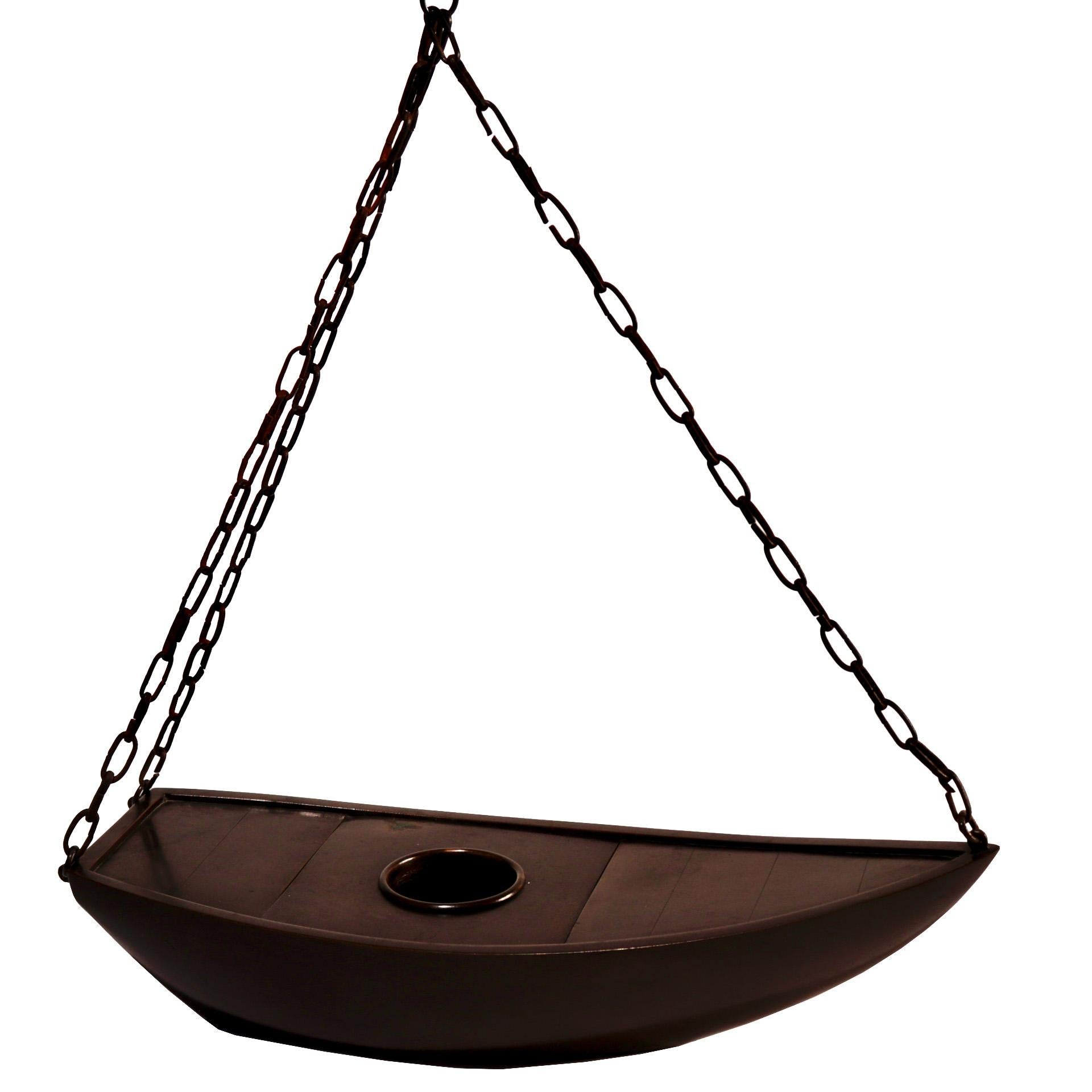 Antique Japanese bronze hanging flower arranging container in the shape of a boat, sharp angular form with flat bottom hull base and center water receptacle sitting within a removable hatch, suspended by an iron chain attached at the tip of the prow