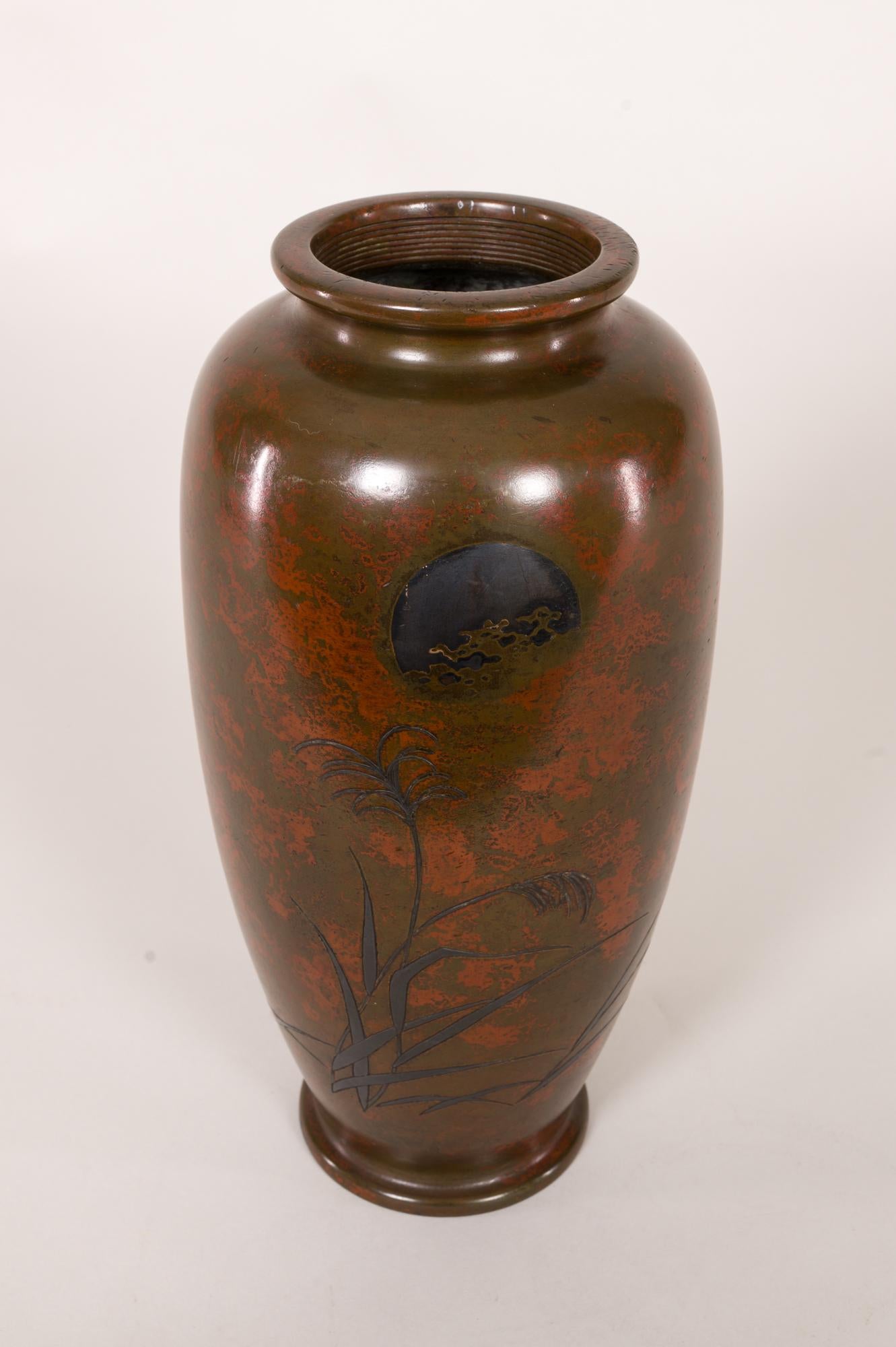 Antiguo jarrón japonés de bronce con paisaje y pátina roja, Periodo Meiji (1868-1912) jarrón de bronce con hierbas silvestres bajo una luna de plata. En todo el jarrón hay un subcolor rojo que representa las nubes. El sello del artista en la parte