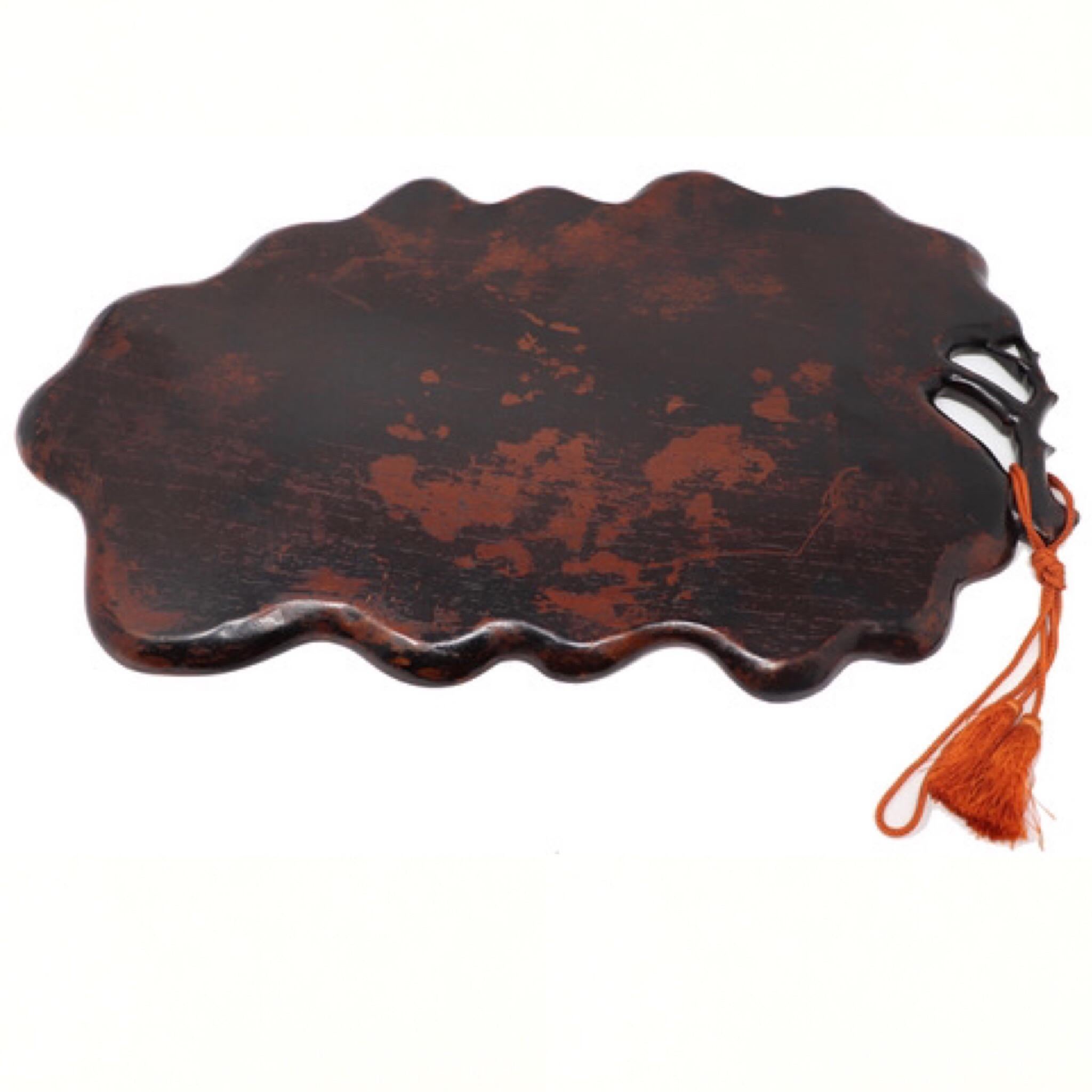 Japanese carved wood tea tray in the shape of a simple large flat leaf, carved from one solid piece of kiri (Paulownia tomentosa) covered in a rich reddish translucent lacquer in several coats, the form with curled up edges with the tip of the leaf