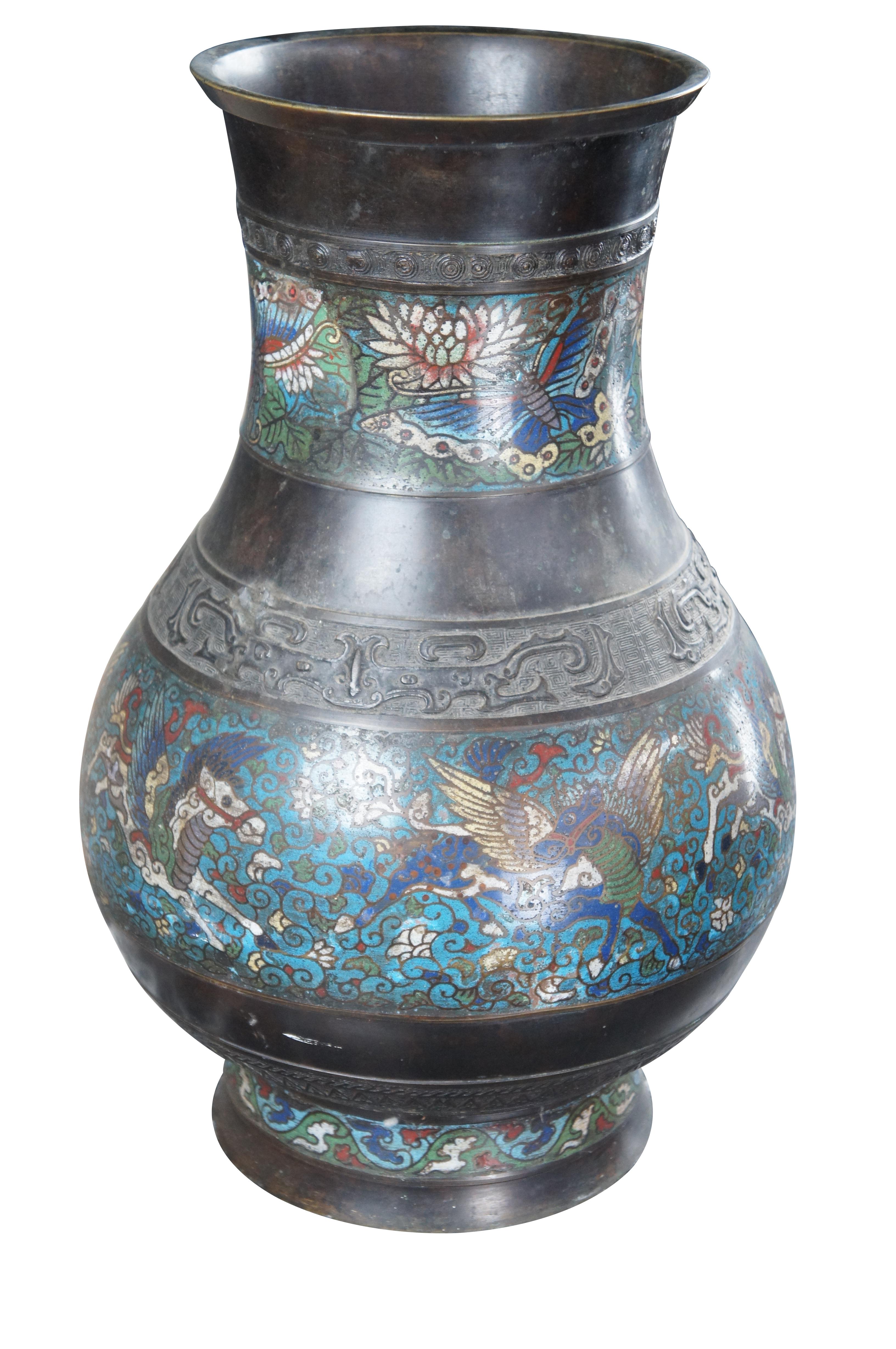 Early 20th century Japanese Bronze Champleve Flower Vase or Urn. Features a colorful champleve design of Pegasus's and butterflies between engraved bronze motifs. Marked Made in Japan on the base.

Dimensions:
19.5