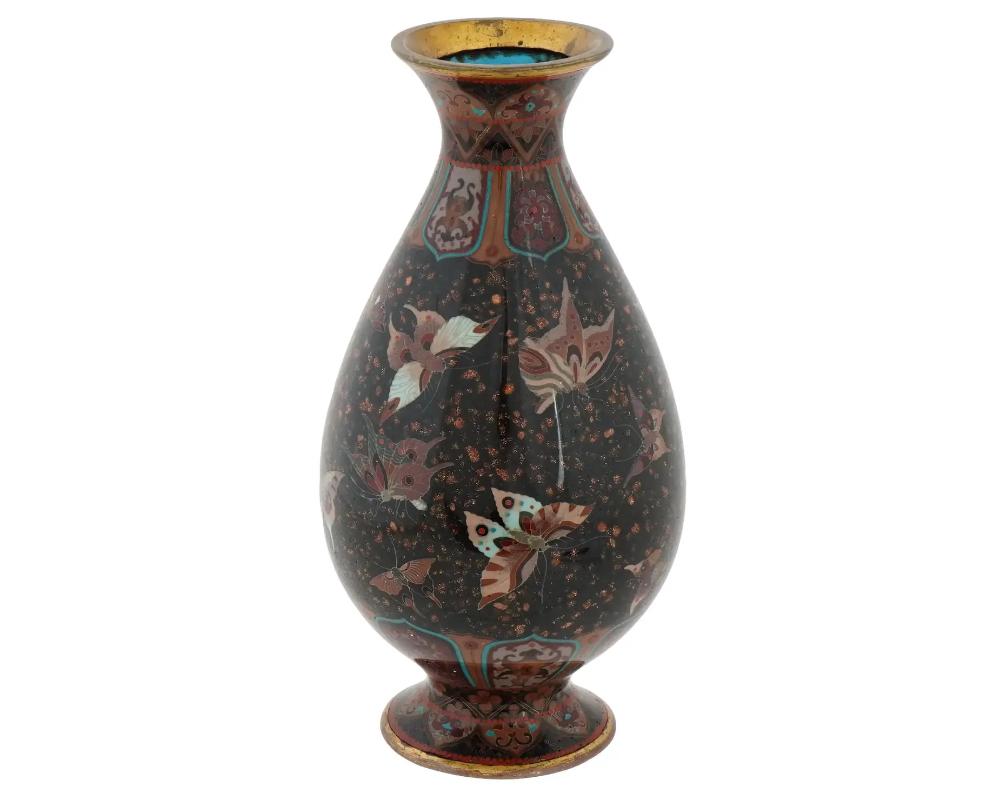 An antique Japanese copper vase with polychrome cloisonne enamel decor. Meiji period. Fish tail shape with pronounced base. Intricate butterfly motif and floral patterns. Gold stone flakes. Gilt rims. High quality. Attributed to Honda Yosaburo,