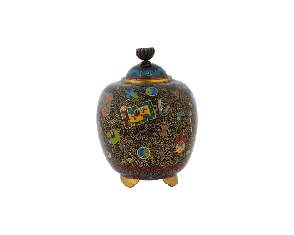 An antique Japanese copper tripod incense burner of Koro type with cloisonne enamel design. Late Meiji period, before 1912. Black body with polychrome decorative motif, daily life objects and abstract ornaments. Collectible Oriental Asian Decor For