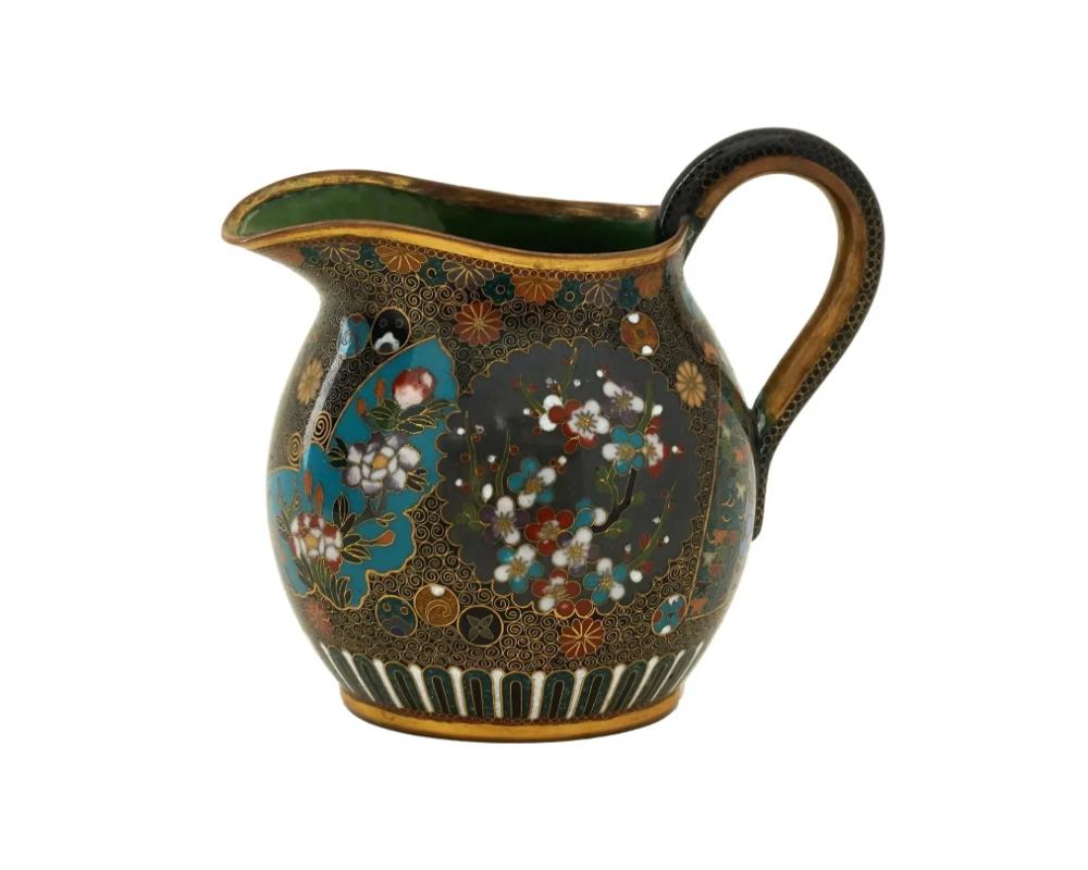 An antique Japanese, late Meiji era, enamel over copper water or milk jug with a curved handle, attributed to the esteemed Kyoto School. Circa: late 19th century

The body is enameled with polychrome figural medallions made in the shapes of a
