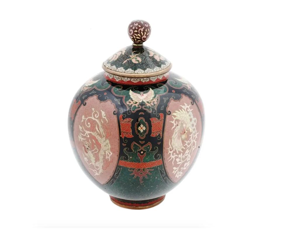 An antique Japanese, late Meiji Era, lidded and footed enamel over brass censer koro or jar. Circa: late 19th century to early 20th century. The sphere form jar is enameled with medallions with Phoenix birds and dragons, surrounded by swirl, foliage