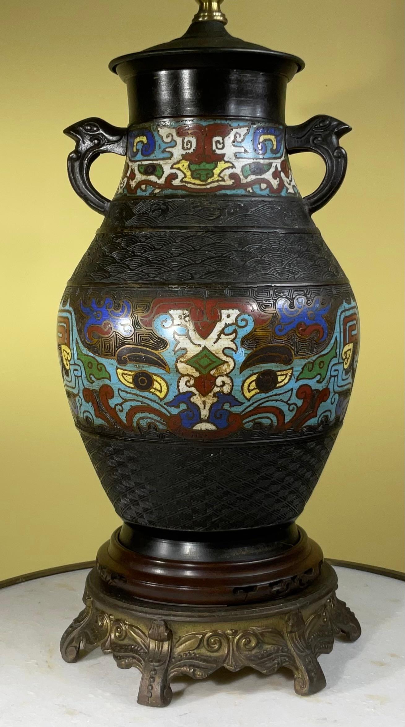 Antique Japanese Cloisonné Lamp, circa 1910, with blue, wine white and turquoise color enamel inlay on bronze vase, mounted on a round hand carved wood base with a secondary gold color metal base, newly electrified and ready to use.