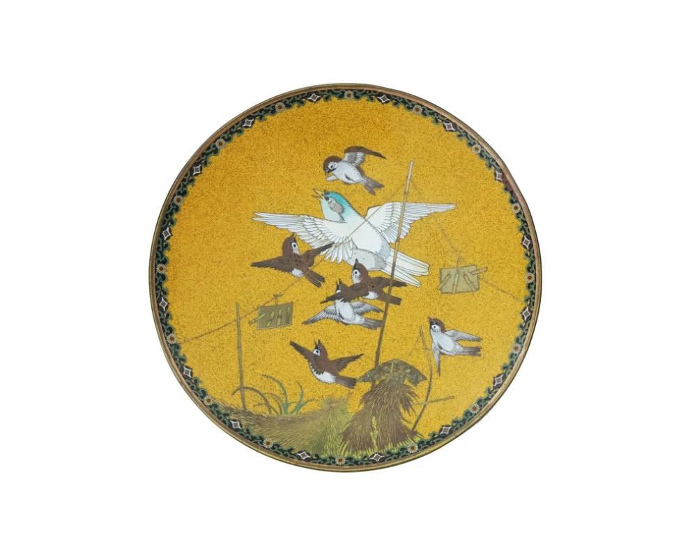 An antique Japanese late Meiji era decorative enamel over copper plate.
The interior of the plate is adorned with a polychrome image of sparrows on the yellow ground made in the Cloisonne technique.
The border features floral and foliage patterns