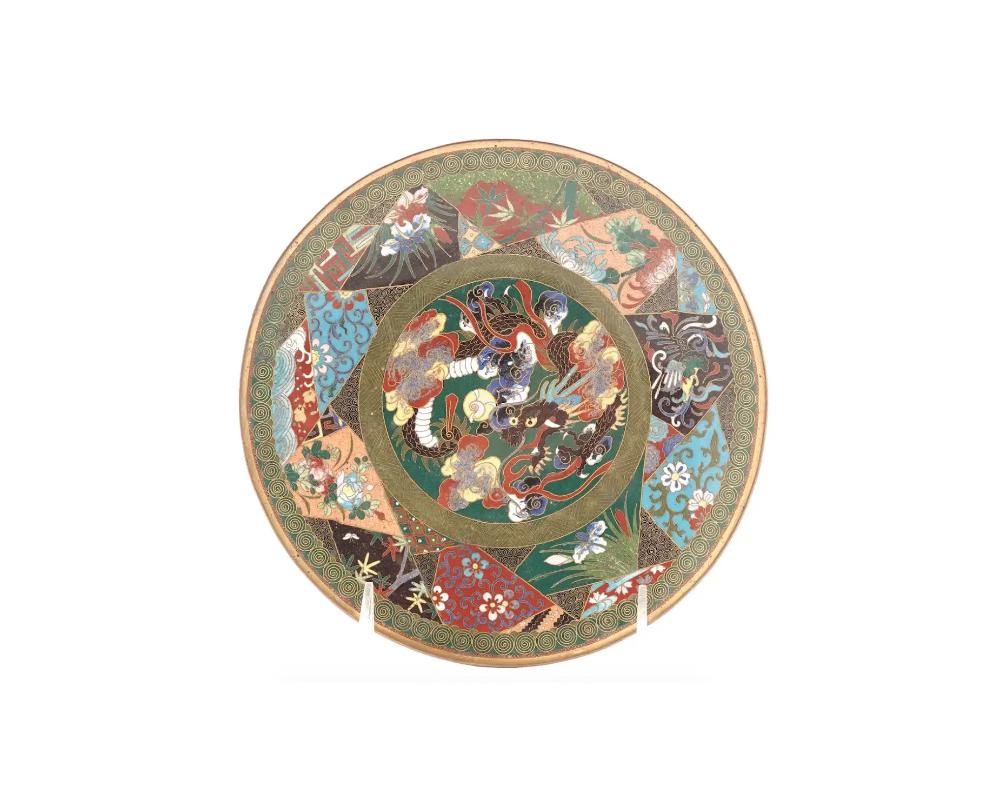A high quality antique Japanese Meiji Era enamel plate. circa: early 20th century. The interior of the plate is enameled with a polychrome medallion with a dragon to the center surrounded by geometrical medallions with polychrome images of
