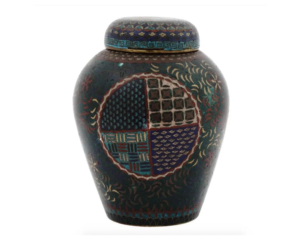 A antique Japanese late Edo Period lidded enamel jar. The jar has a globular shaped body. The exterior of the vase is adorned with medallions with various geometrical patterns surrounded by floral and foliage motifs made in the Cloisonne technique.