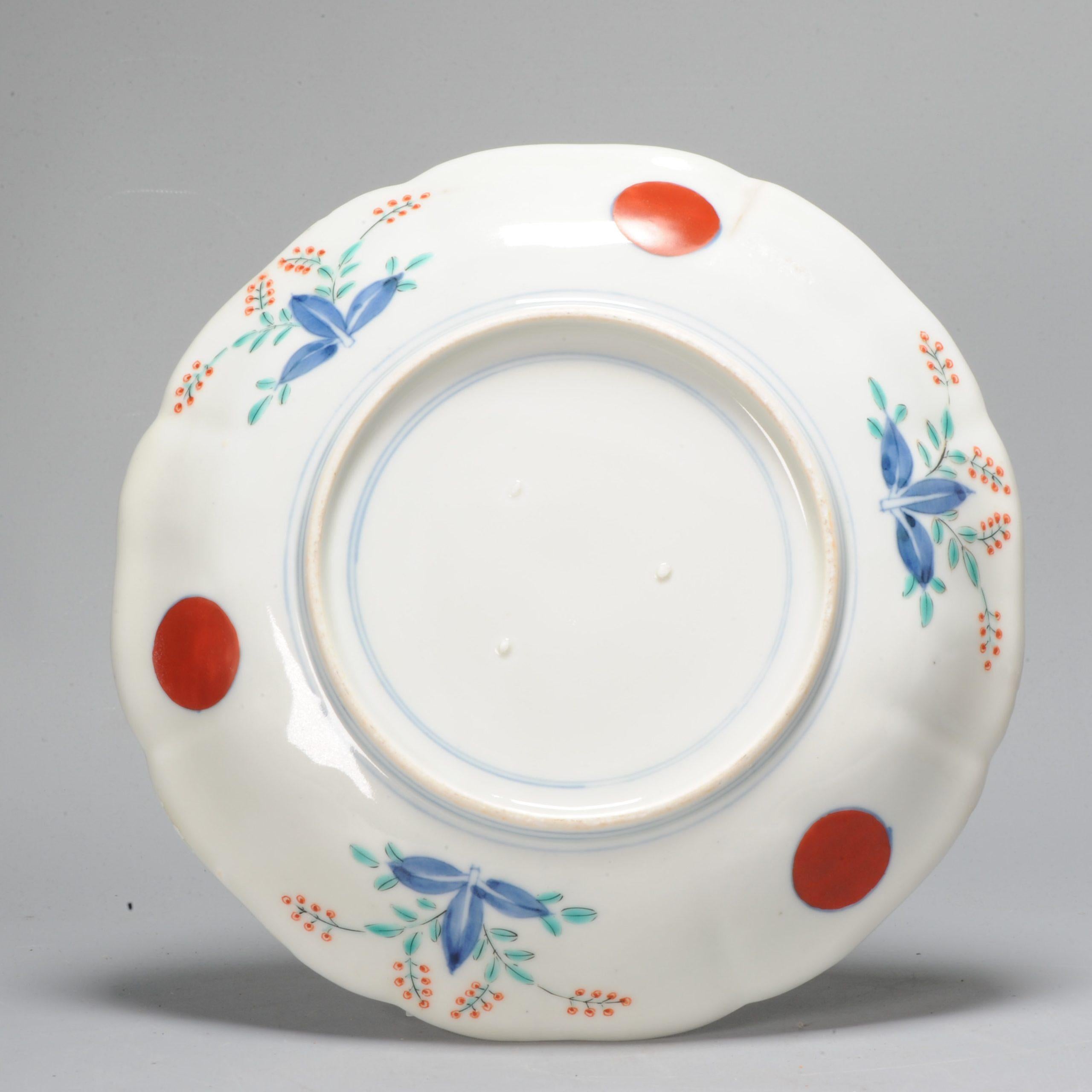 This amazing Japanese porcelain dish. Painted in underglaze blue as well as with polychrome enamels. This is most probably part of the Kakiemon family. Central a flower basket with prunus tree and birds flying on the top left. The border with rocks,