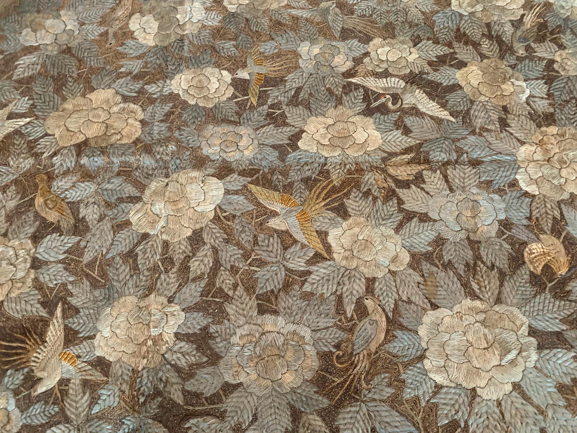 Großer japanischer Seidenstickerei-Wandteppich, ca. 19. Jahrhundert, späte Edo- bis frühe Meiji-Zeit. Sorgfältige Handarbeit, die dicht wiederholte Motive von Vögeln im Flug zwischen üppigen Pfingstrosenblüten in der zentralen Tafel darstellt, die