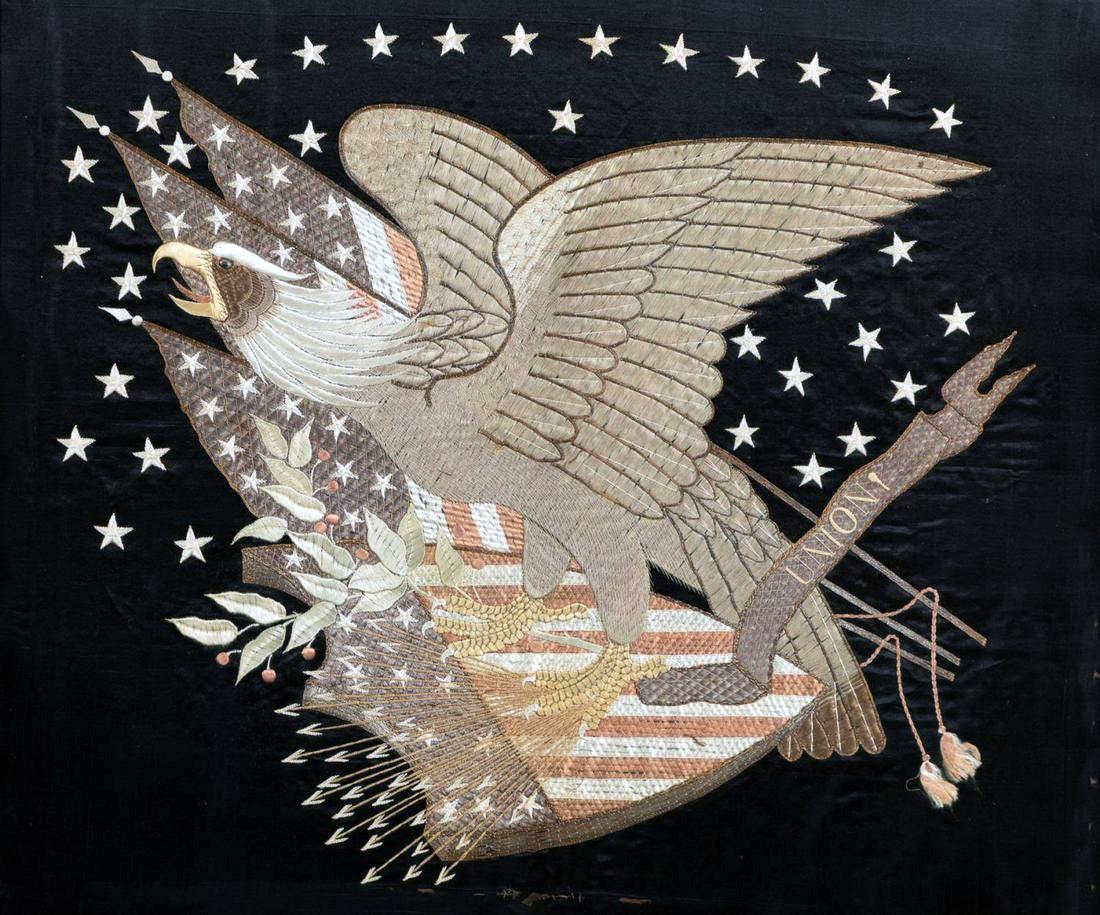 Eine faszinierende Seidenstickerei, die einen amerikanischen Adler auf einem Schild zeigt, mit Lorbeerzweigen und schießenden Pfeilen unter den Füßen und amerikanischen Flaggen auf der Rückseite. Vierunddreißig große Sterne sind im Hintergrund