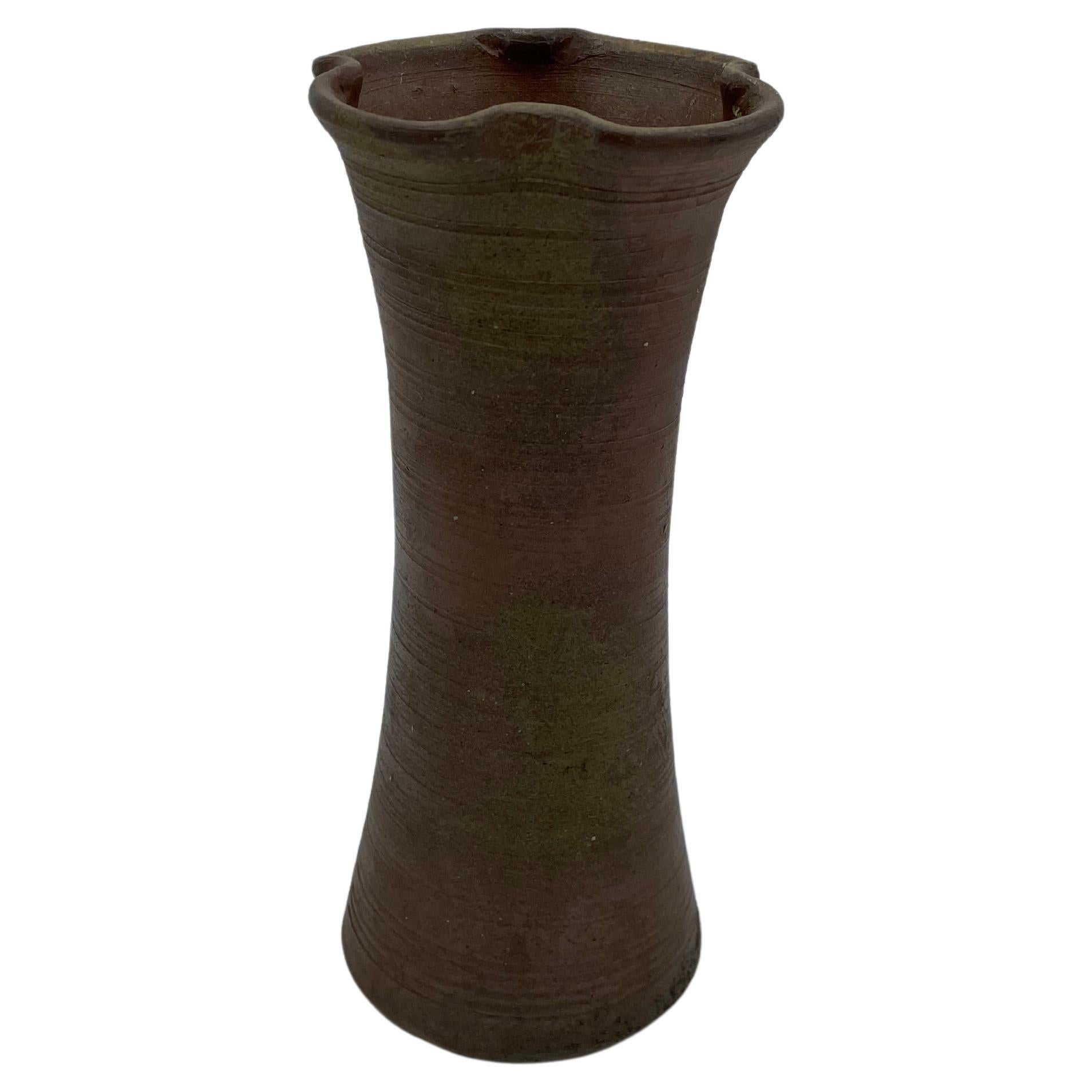 This is an antique flower vase made in Japan around 1970s.
The style of technique is Bizen ware (Bizen-yaki).

Bizen yaki is a type of Japanese pottery traditionally from Bizen province, presently a part of Okayama prefecture.
Bizen yaki has a