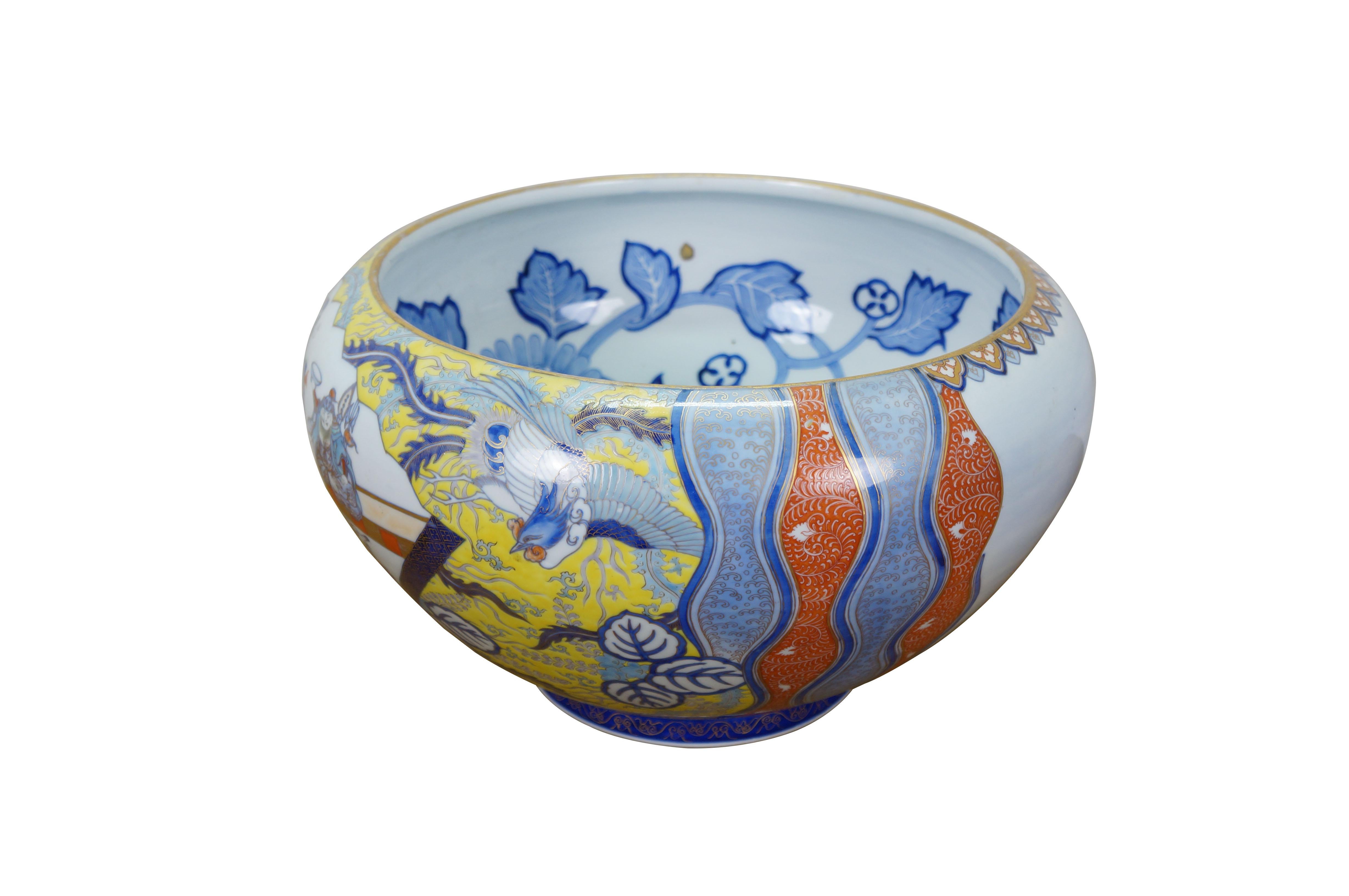 Ciotola per pesci da centro Meiji di Fukagawa Porcelain, risalente all'inizio del XX secolo.  Grande ciotola a forma di cipolla dipinta su un lato con una scena di figure/saggi/geishe e ratti antropomorfi, incorniciata da disegni dai colori vivaci e