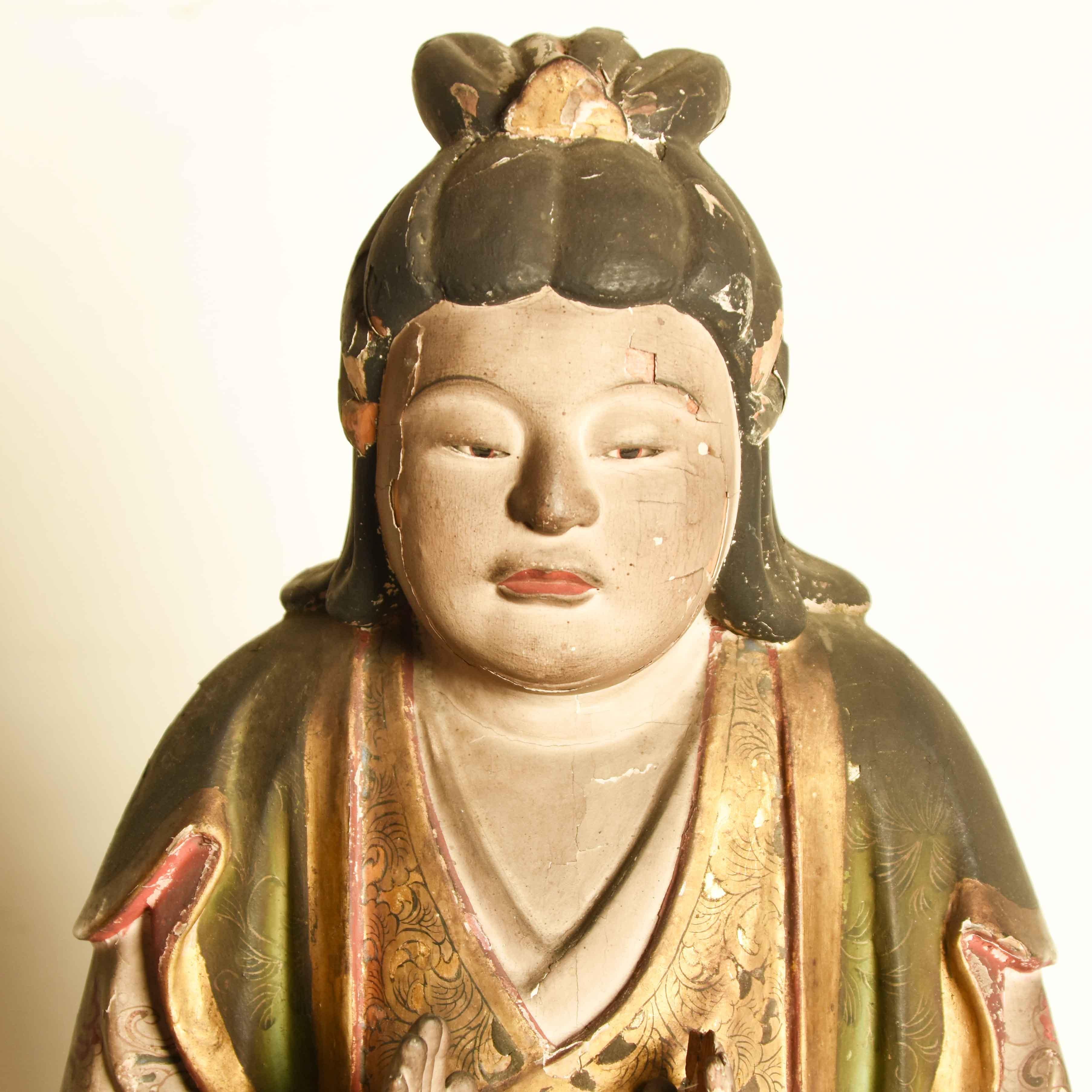 Eine japanische Statue eines Shinto-Gottes aus der Momoyama-Periode. Handgeschnitzt aus Holz mit einer Gesso-Schicht und handbemalt mit fließenden Gewändern mit fein gearbeiteten, farbenfrohen Mustern, darunter ein Lotus auf der mittleren Tafel. Die