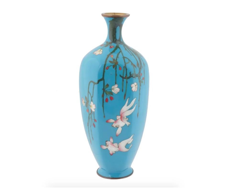 An antique Japanese Meiji era Ginbari enamel vase. The ground of the vase is enameled in a turquoise shade. The vase is enameled with polychrome images of fish and blossoming sakura flowers made in the Cloisonne technique. Ginbari is a Japanese
