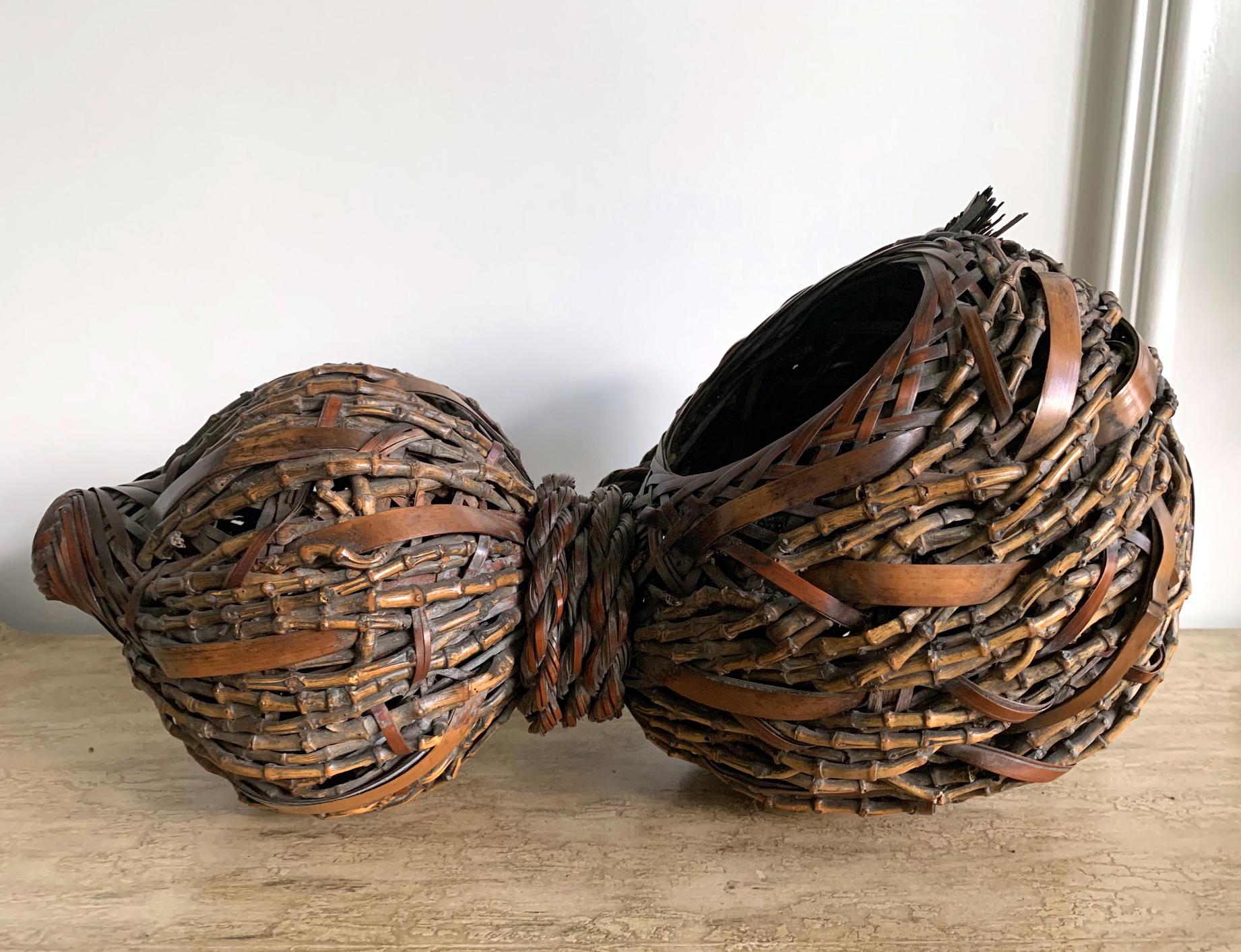A lovely Japanese bamboo ikebana basket in the shape of gourd with an open mouth and a body circa 1920s-1940s. The piece was woven in great details and styles with mostly irregular and loose twining weaving technique. Several different kinds of