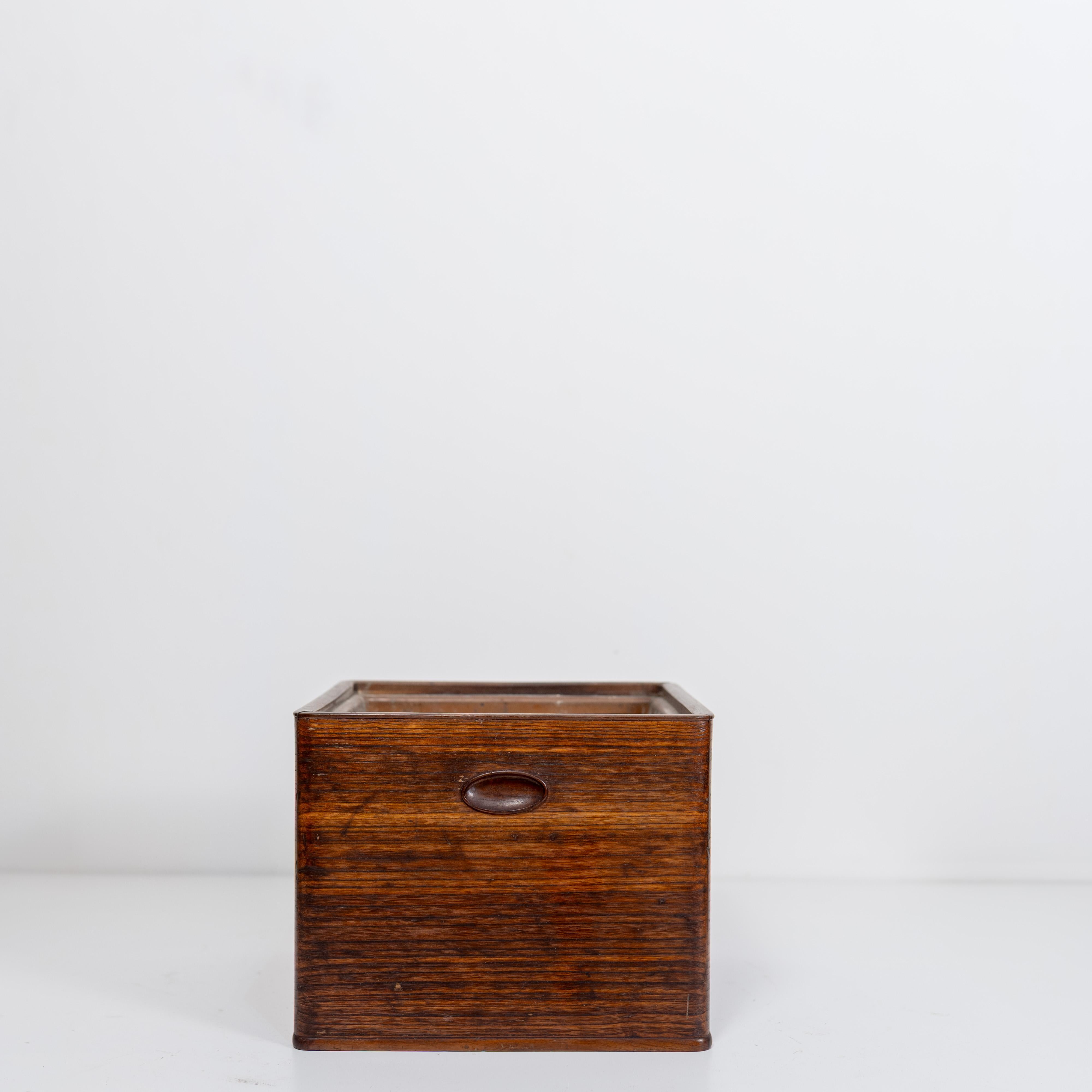 Un authentique hibachi japonais, traditionnellement utilisé comme brasero portatif pour le chauffage et la préparation du thé. Fabriquée en bois avec une patine chaude, cette pièce conserve son intérieur métallique d'origine et est livrée avec des
