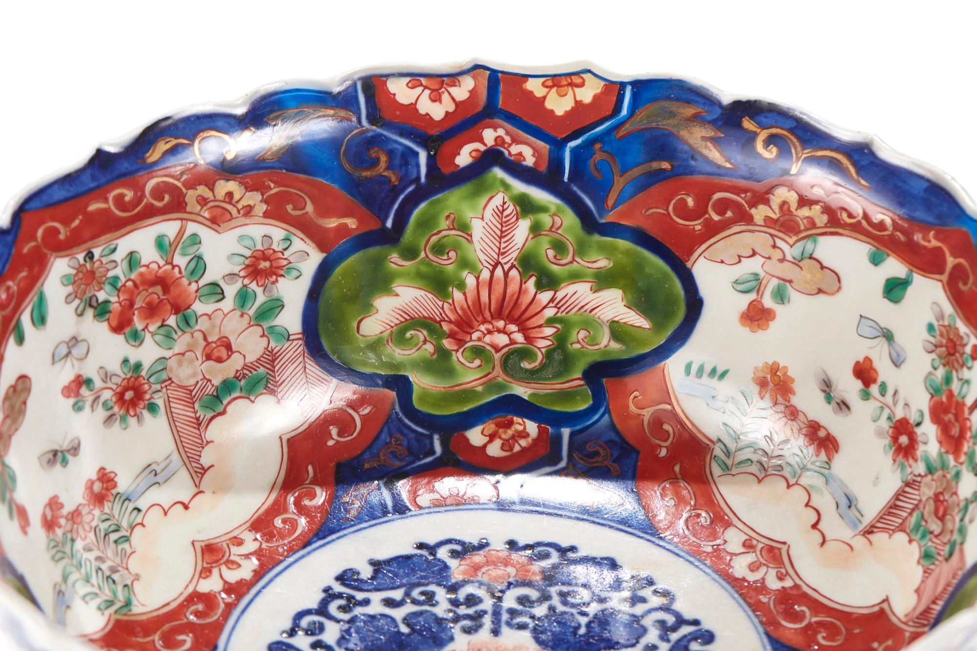 Antique Japanese Imari Lotus shaped bowl, painted in under-glaze blue with foliage and shaped reserves, picked out with further flowers and insects in red and green poly-chrome enamels, gilt highlights, raised circular foot with further under-glaze