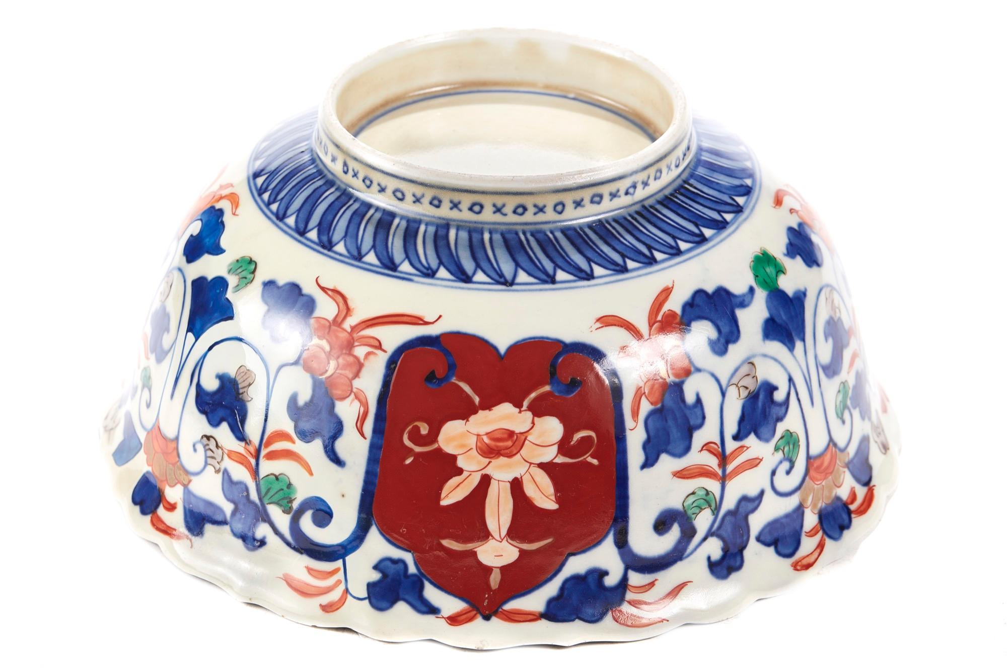 Antique Japanese Imari Lotus shaped bowl beautifully painted in under-glaze blue with foliage and shaped reserves picked out with further flowers and insects in red and green poly-chrome enamels. It boasts gilt highlights and is raised on a circular