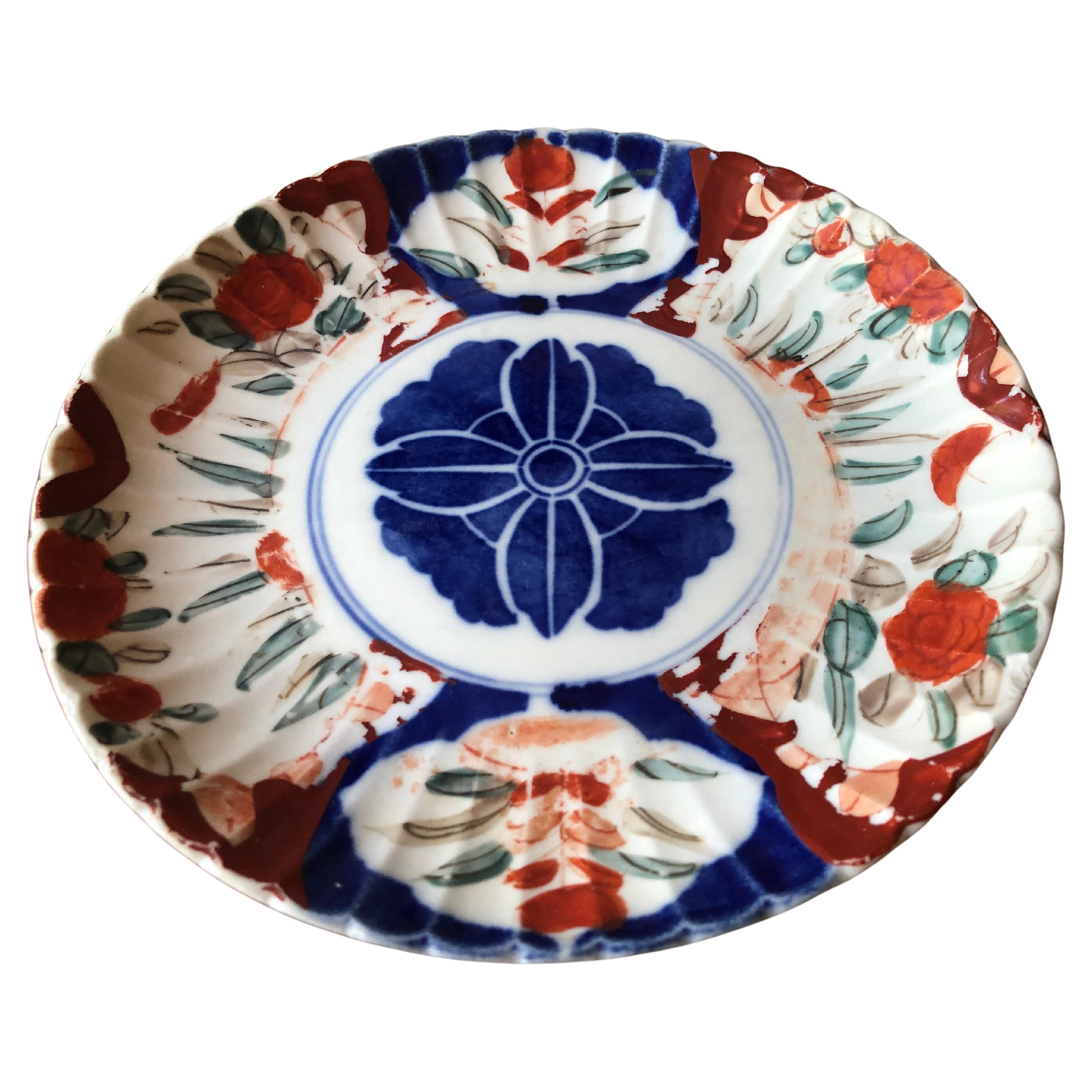 Wonderful 18th to 19th century antique Imari plate with scalloped rim.
Hand painted with central blue medallion, surrounded vibrant orange, crimson, blue, and green patterns. Unmarked on bottom.
