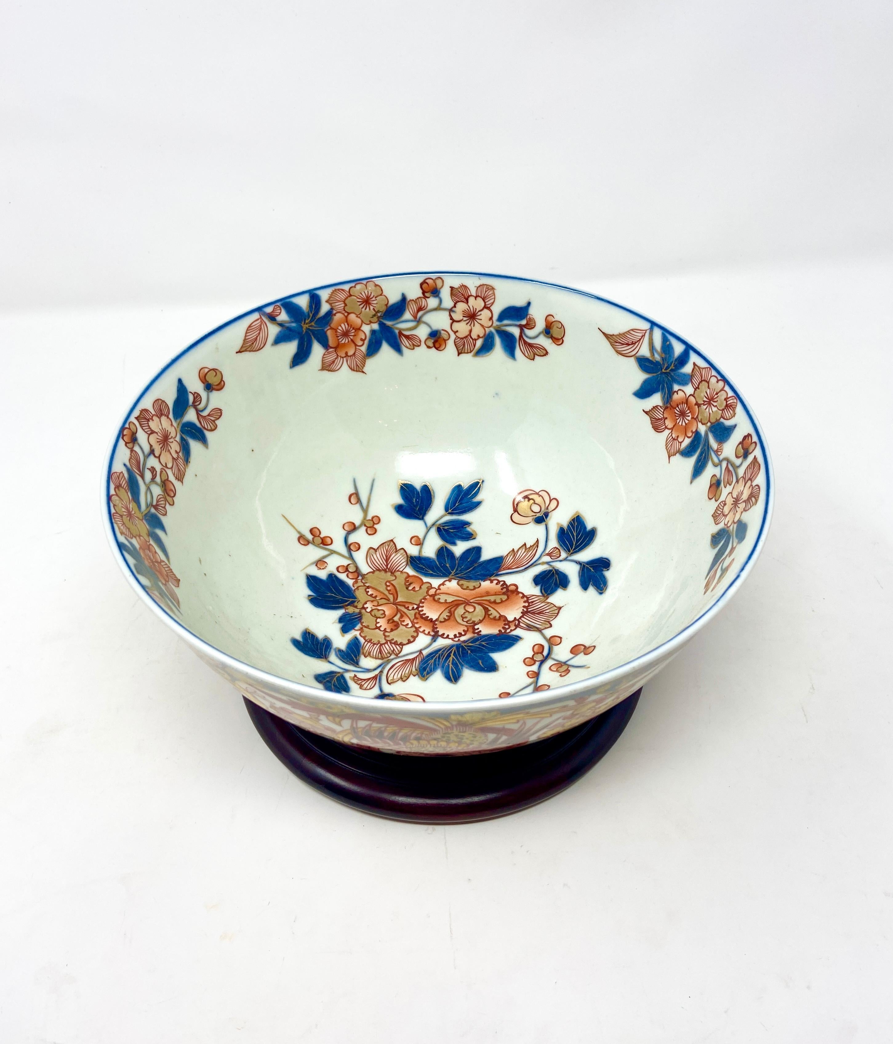 Antique Japanese Imari porcelain bowl on teakwood stand, Circa 1900.
Dimensions with stand: 
H: 6 inches 
D: 10 1/2 inches.