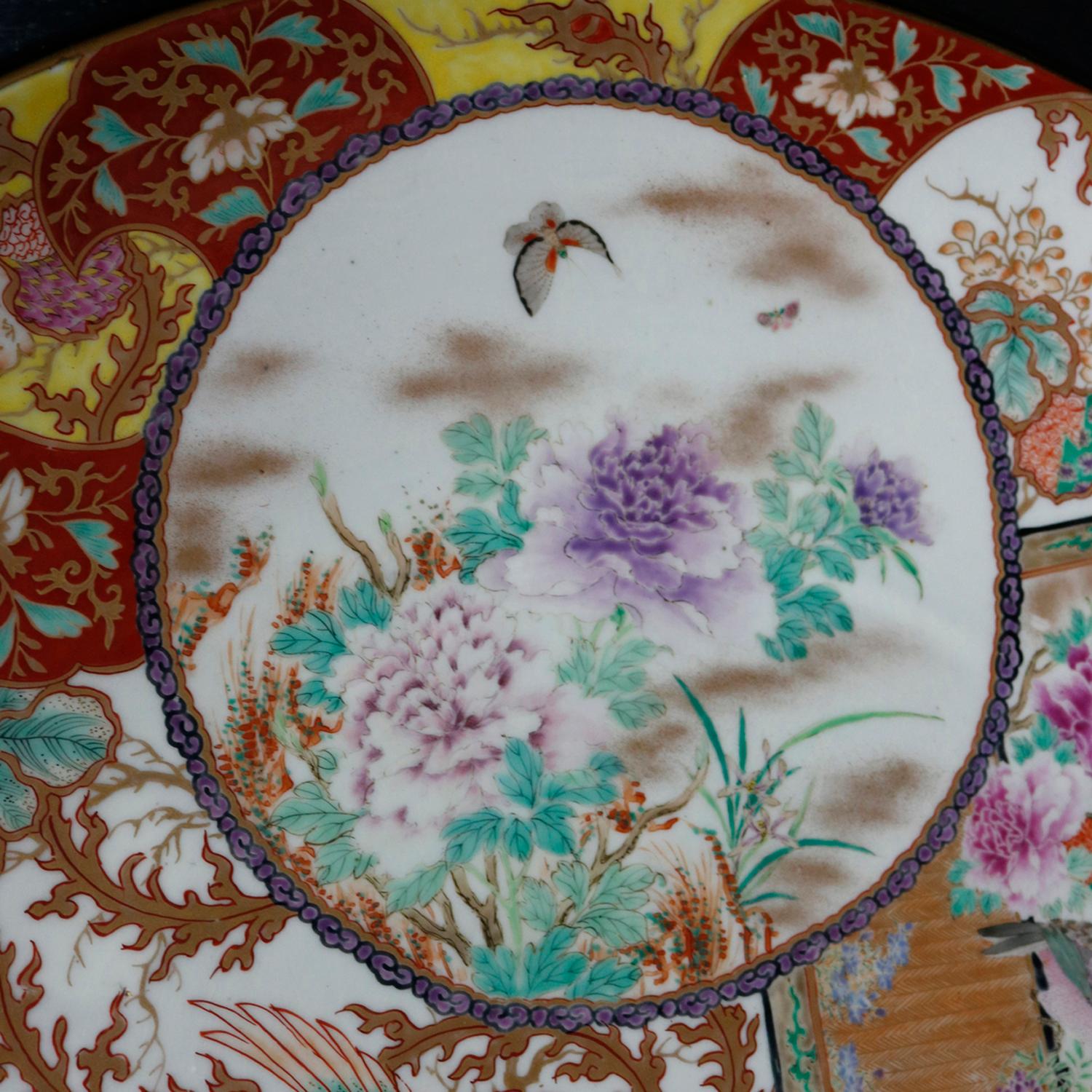 Antique Japanese Imari Meiji Charger by Hichozan Shinpo-sei offers hand enameled and gilt garen scene reserves with flowers and birds, en vers signed and with ragon decorated rim, seate in shadow box type ebonized frame, 19th century.
(Hichozan