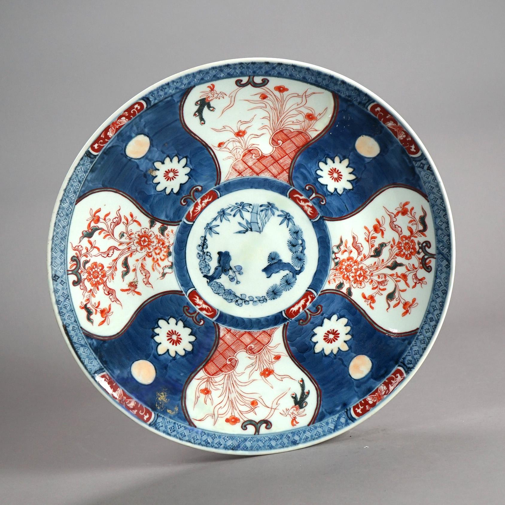 An antique Japanese Imari charger offers porcelain construction with hand painted garden reserves and en verso floral pattern with central maker stamp, c1920

Measures- 2.25''H x 18.5''W x 18.5''D