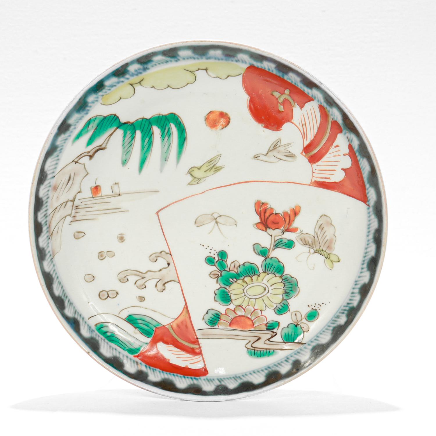 Ein feiner antiker japanischer (oder chinesischer) Porzellanteller.

Auf weißem Grund ist eine Meereslandschaft mit Blumen und Vögeln in Grün-, Rot-, Gelb- und Brauntönen abgebildet.

Der Rand ist mit einem blauen Unterglasurmuster