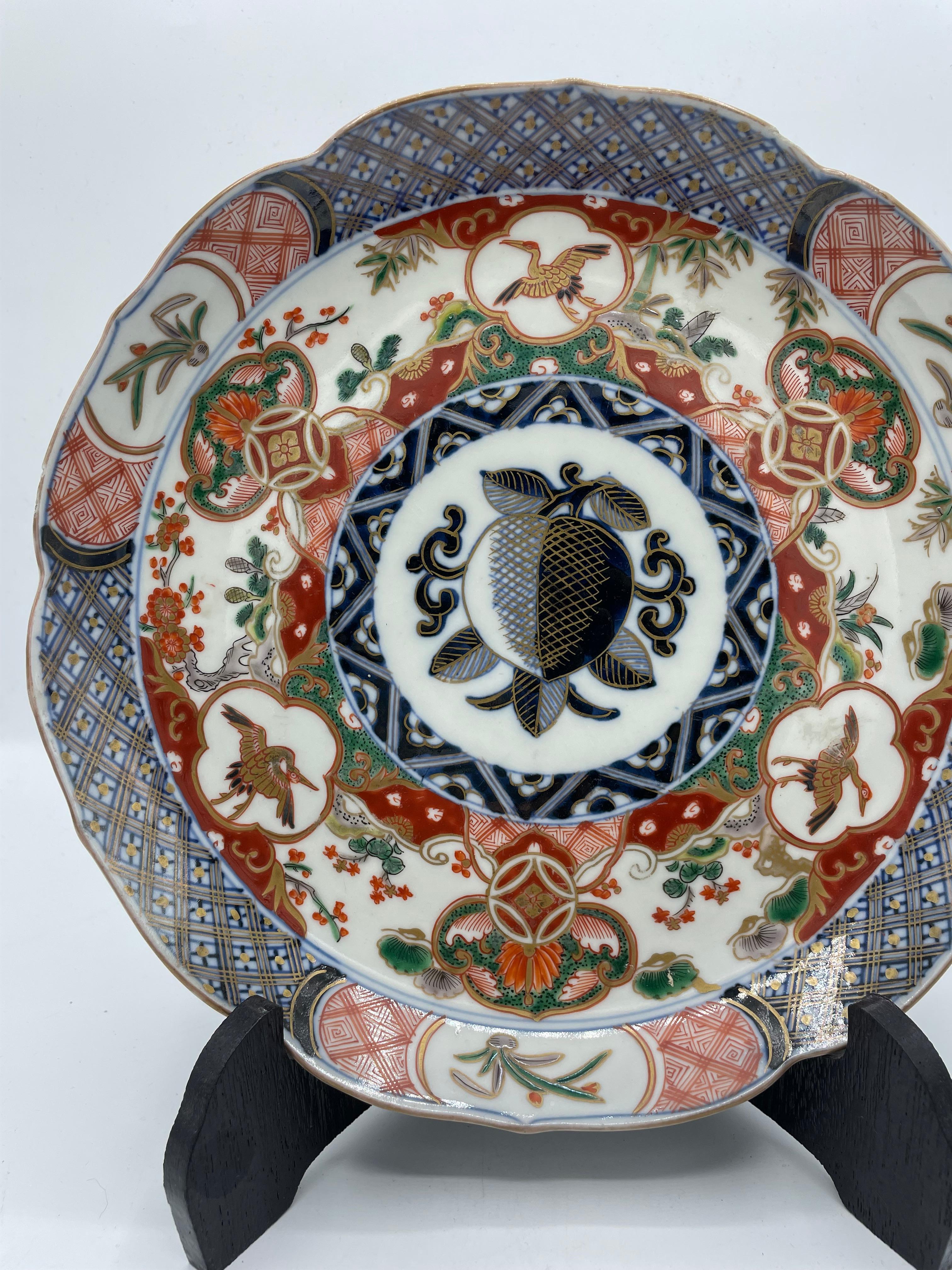 This is a plate which was made in Japan in Showa era (around 1960s).
It was made with Imari yaki technique.

Imari ware is a Western term for a brightly-coloured style of Arita ware. Japanese export porcelain made in the area of Arita, in the