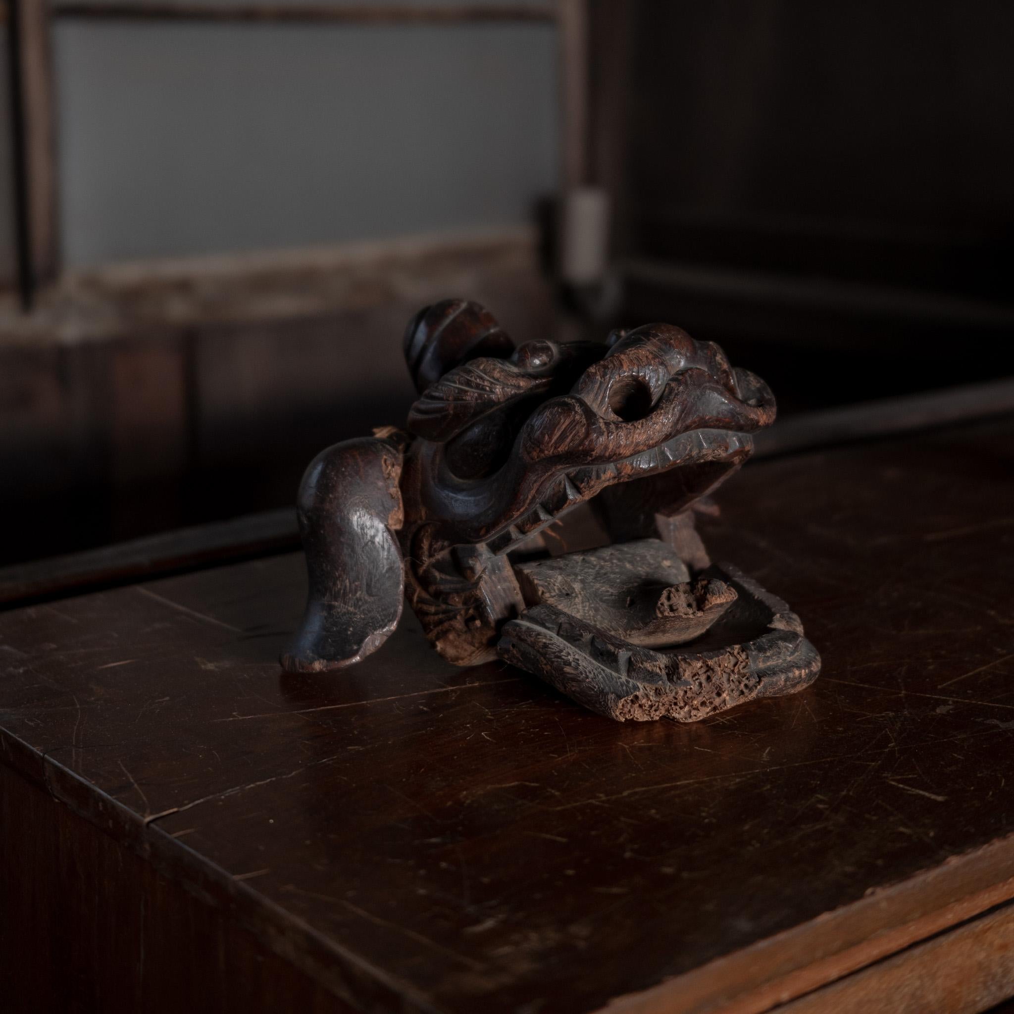 This expressive carved wooden head represents a Koma-Inu — the mythical lion-dog guardians traditionally placed at the entrances of Shinto shrines to ward off evil spirits.

Whether placed as a sculptural accent on a shelf or used as a centerpiece