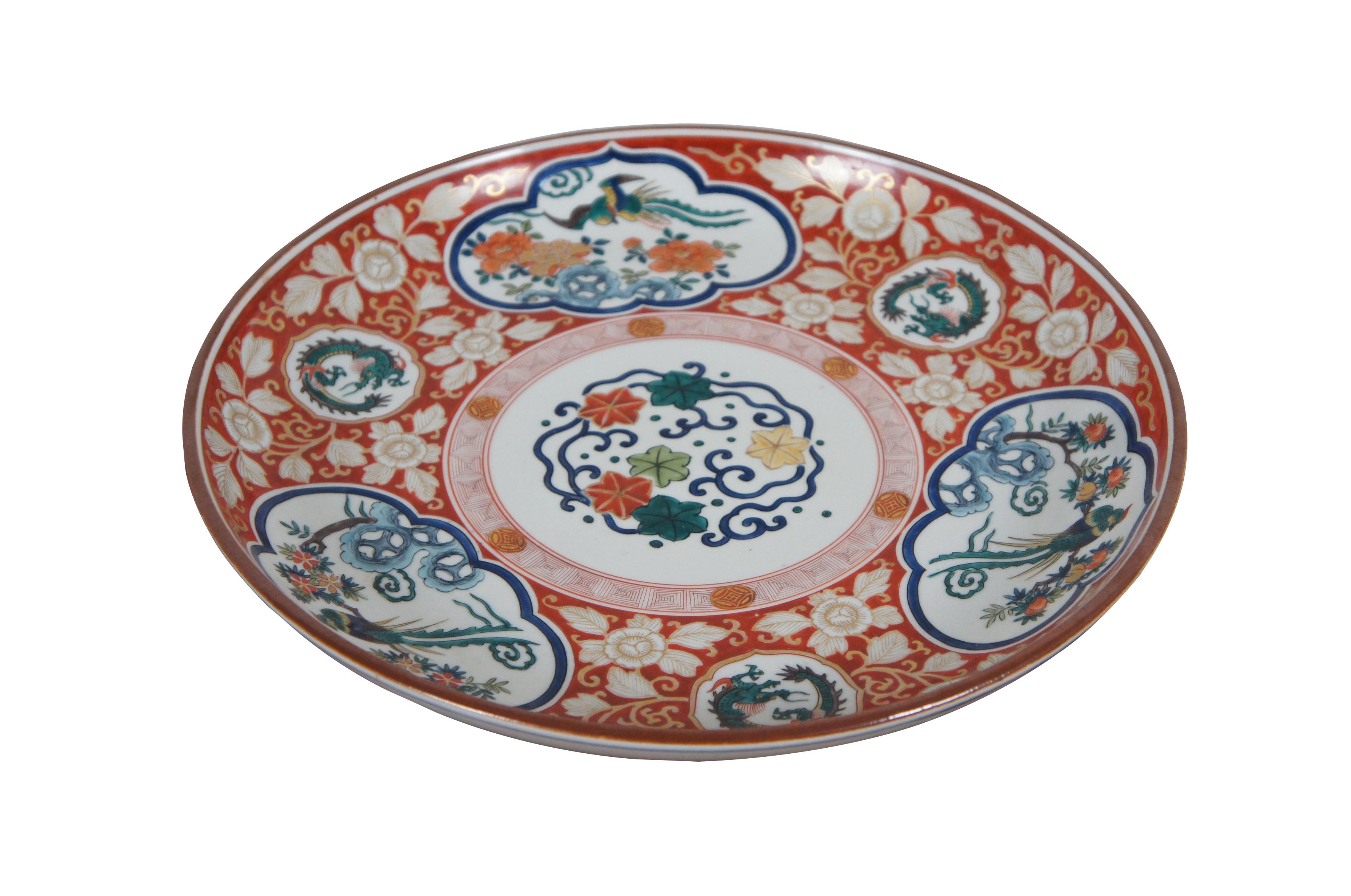 Early to mid 20th century Japanese kutani / imari style serving plate / platter - white porcelain hand painted with spiraling dragons and phoenixes / pheasants  by flowering trees, surrounded by a red and gold floral motif. 

Dimensions:
13.25