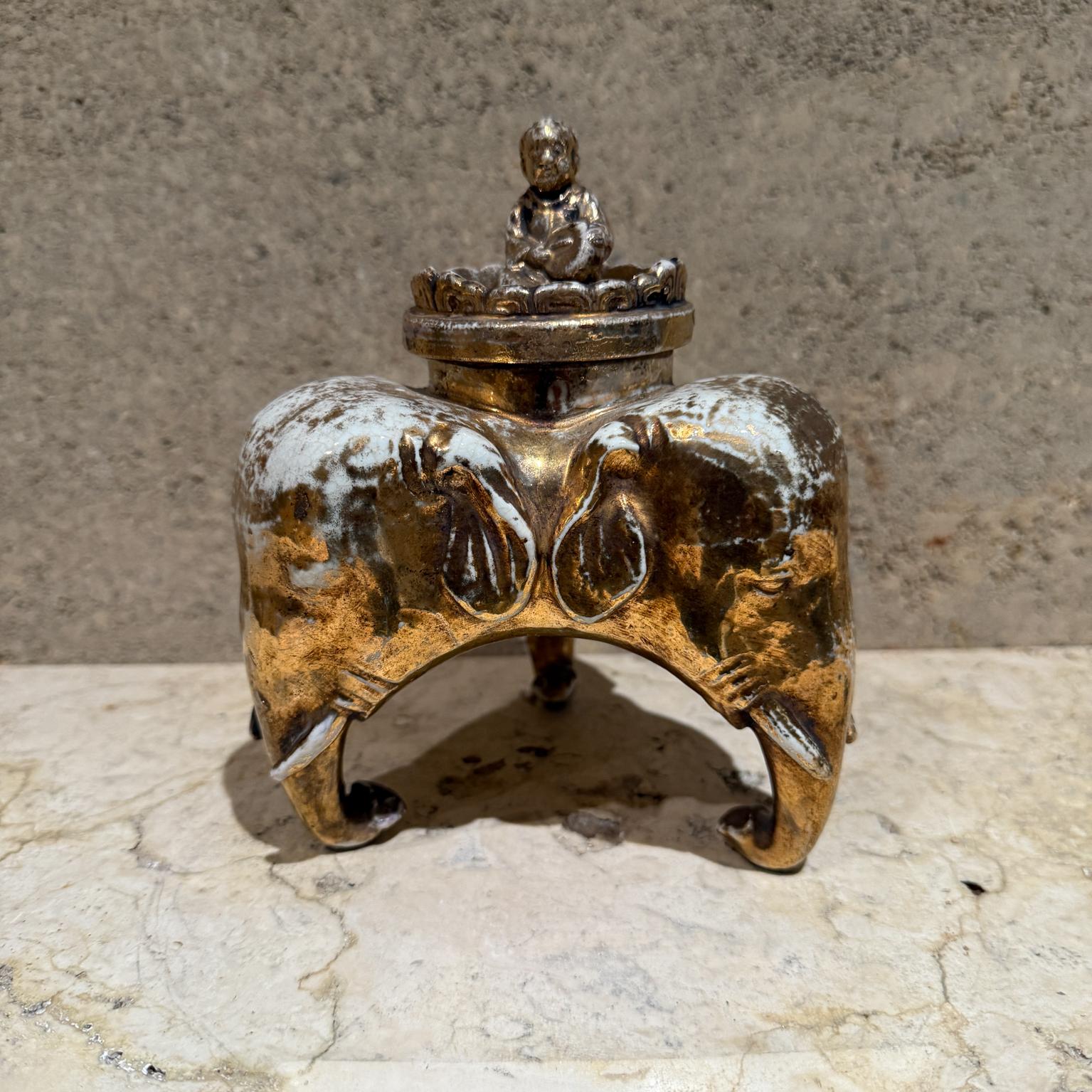 For your consideration, an Antique japanese Kutani porcelain tripod incense burner by Taniguchi.

Tripod container ( assume is an incense burner) made on porcelain with gilt finish. Each leg has the head of an elephant. On the top lid a Buddha