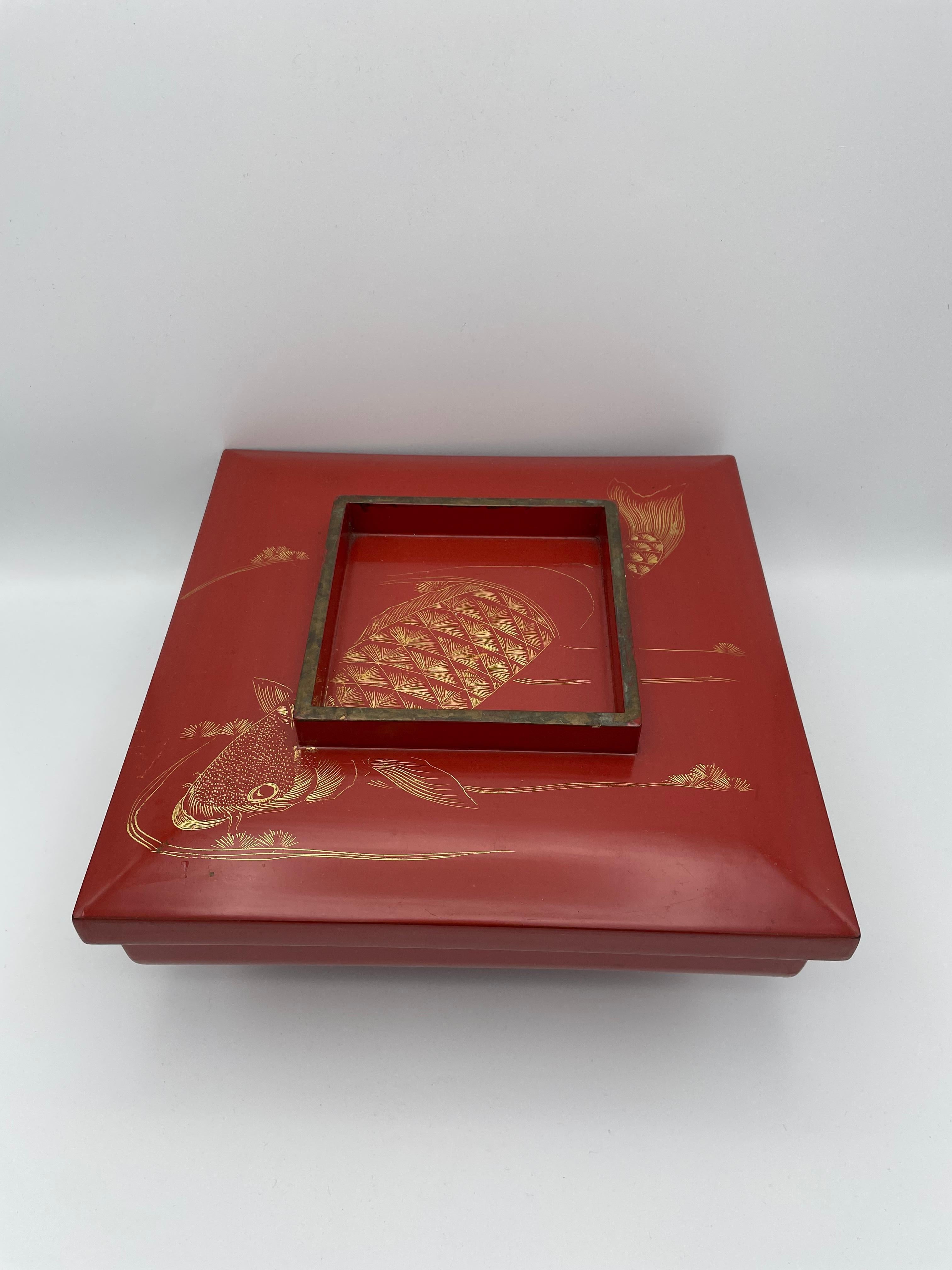 This is an antique lacquered box with a lid made around 1950-1970s in Showa era. The dimensions are 25.5 ×25.5 × H9.5cm.
It can be used as a jewelry box or a decoration object.
The lid of this box is engraved in gold with a picture of a carp