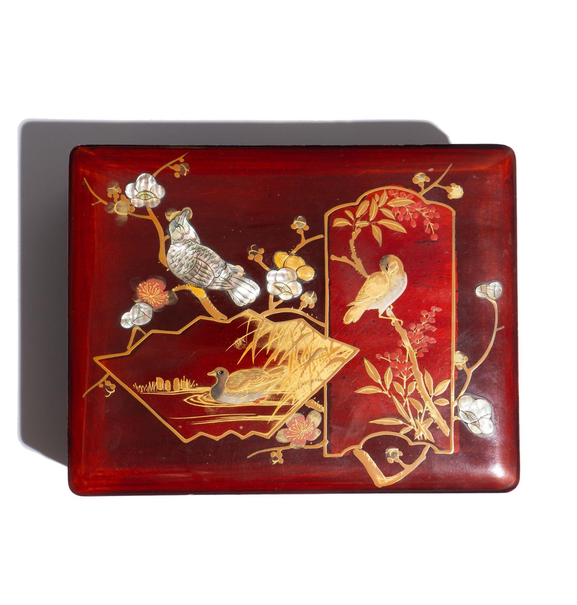 Japanese lacquered box with hinged lid. The lid is decorated in gilt with red enamel and abalone inlays on a burgundy red ground. A motif of birds and apple blossoms are rendered in three over lay vignettes.
Japan, circa 19th century.