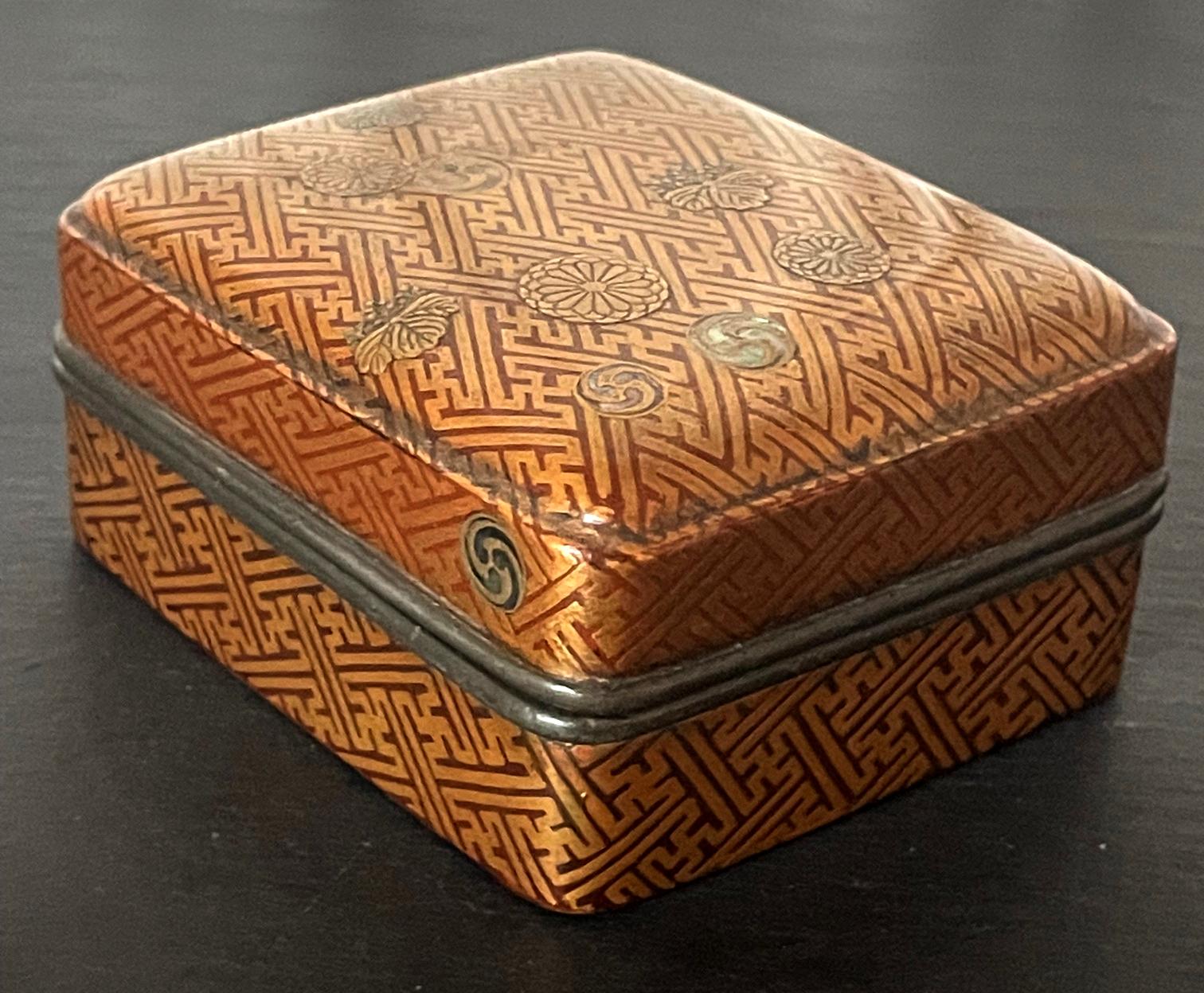 An old Japanese lacquered small box likely used to contain incense powder called Kobako, circa Edo period (17-18th century). The rectangular form box with a fitted lid features rounded corners and a subtle conforming inner line framing the designs.