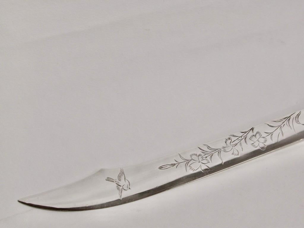 Antique Japanese letter opener, sterling silver handle, silver plated blade,1880
The handle has 2 japanese women holding a pot on one side and a man
 holding it on the other side.
The blade has a scimitar shape blade with aesthetic engravings on