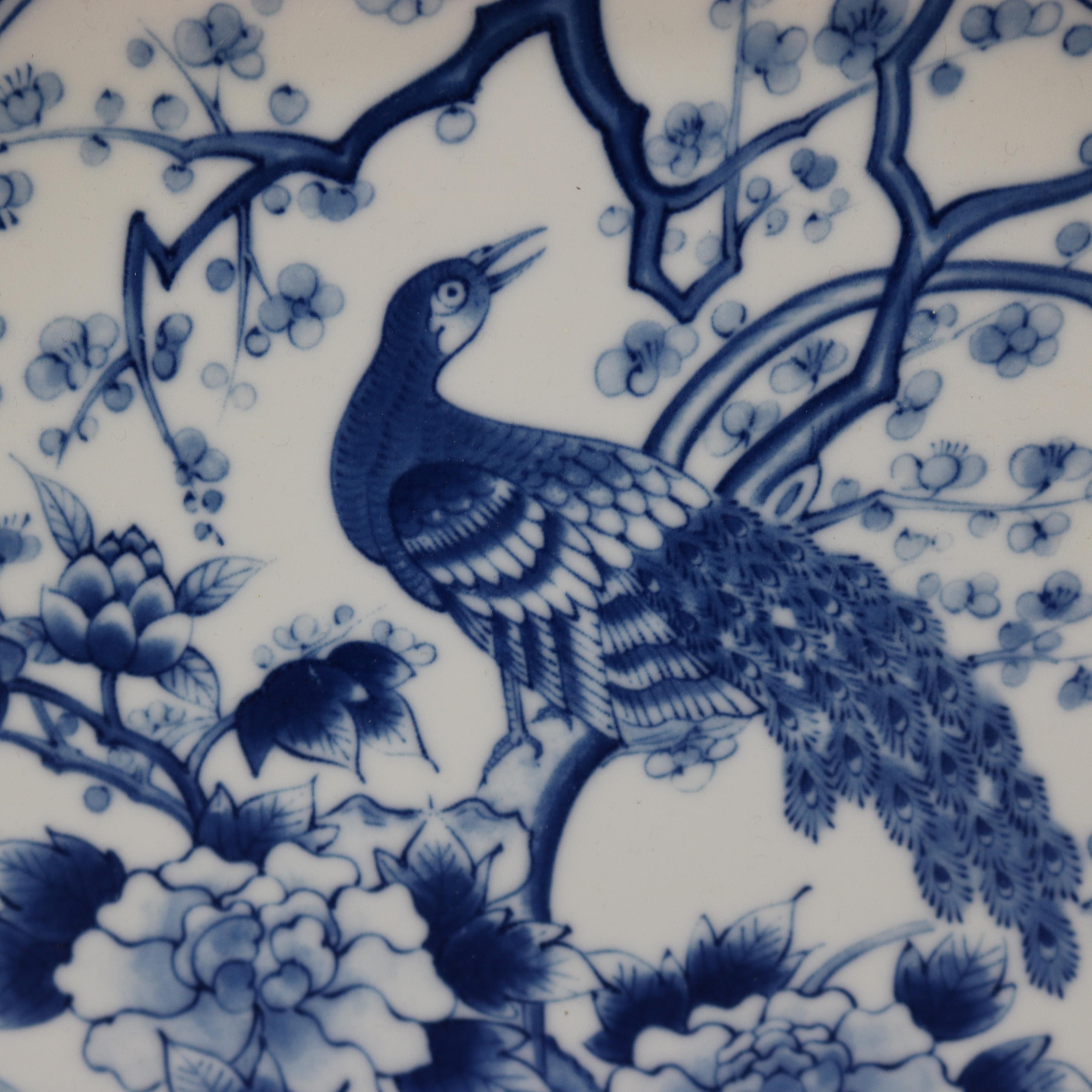 An antique Japanese Meiji low bowl offers blue decorated porcelain with central garden scene having peacock with lattice surround having foliate reserves, en verso signed as photographed, 20th century

Measures: 2.5