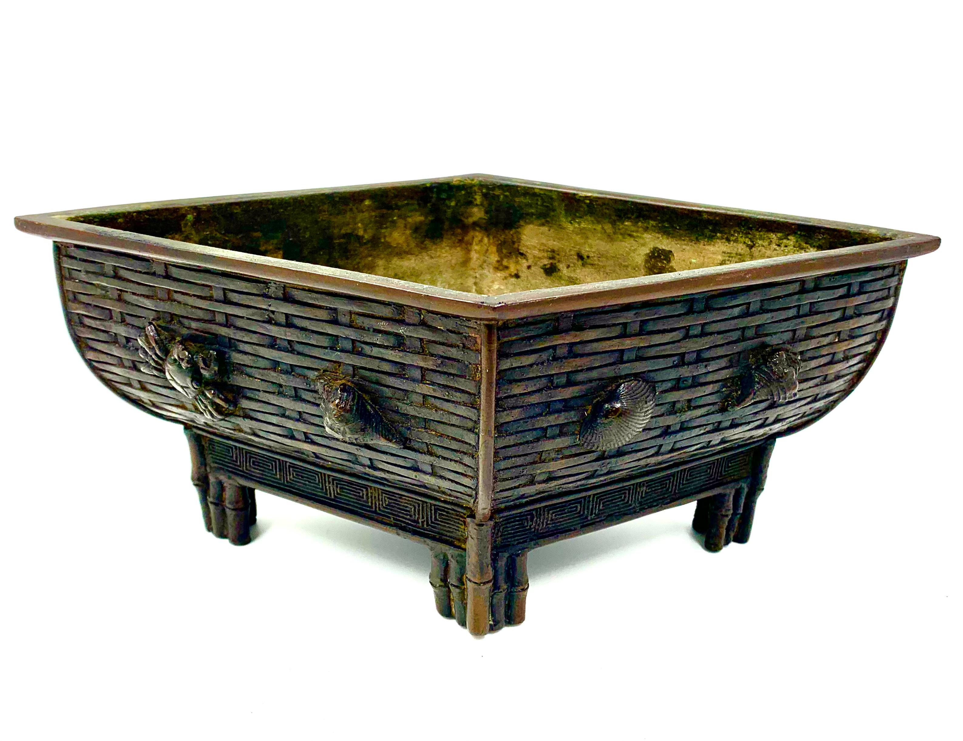 Unusual rhombus shaped Japanese Meiji period bronze sea-life motif bonsai, bamboo planter, ikebana. The body in the form of a densely woven basket of fine detail, with a large lobster, clam shell, cockle, conch, crab, pearl oyster and whelk