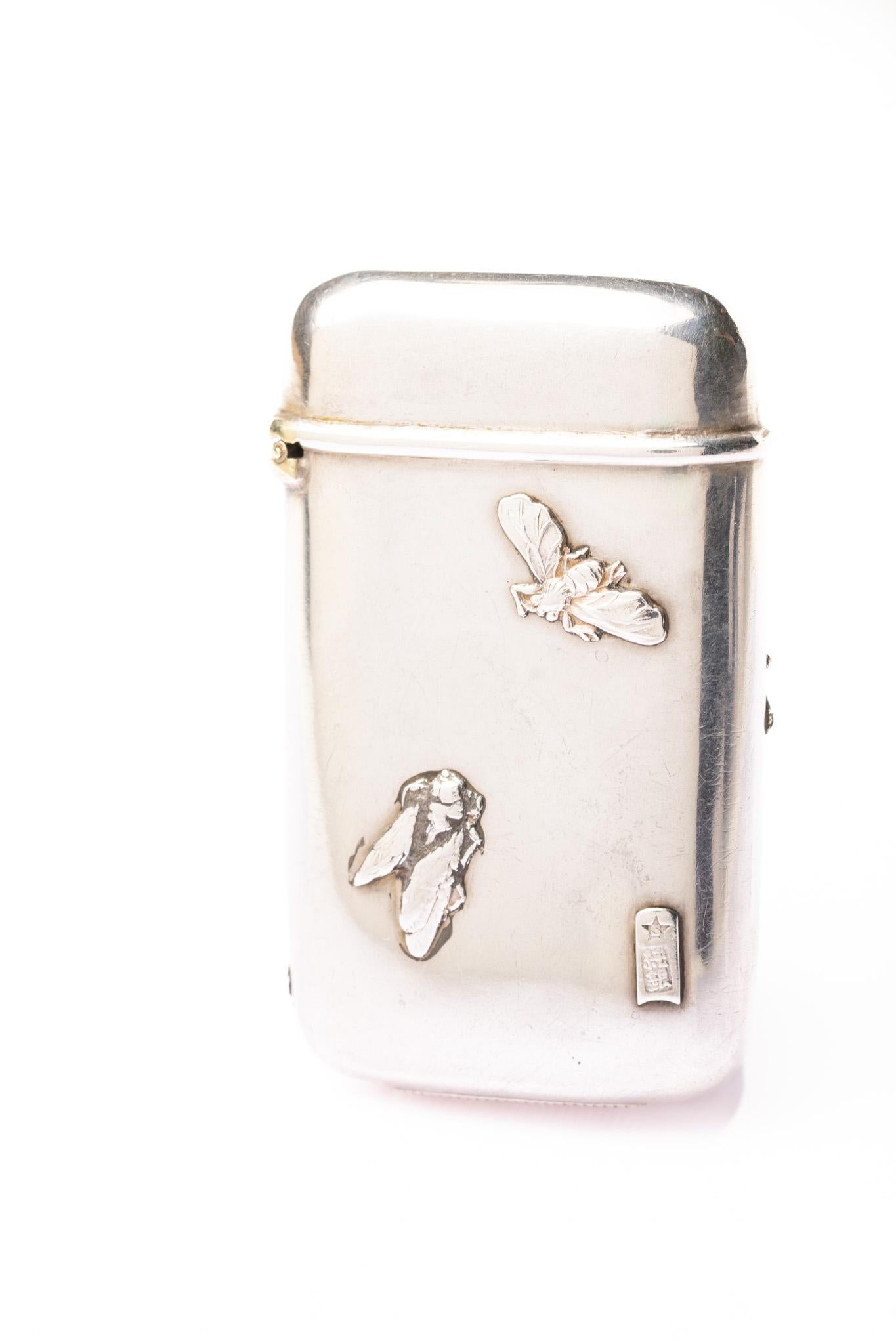 Este rarísimo estuche de vesta de plata japonesa antigua Meiji está decorado con un cerezo en flor en una cara y un par de insectos en el reverso. La vesta tiene una marca de plata de dos caracteres en la parte inferior derecha

Periodo: