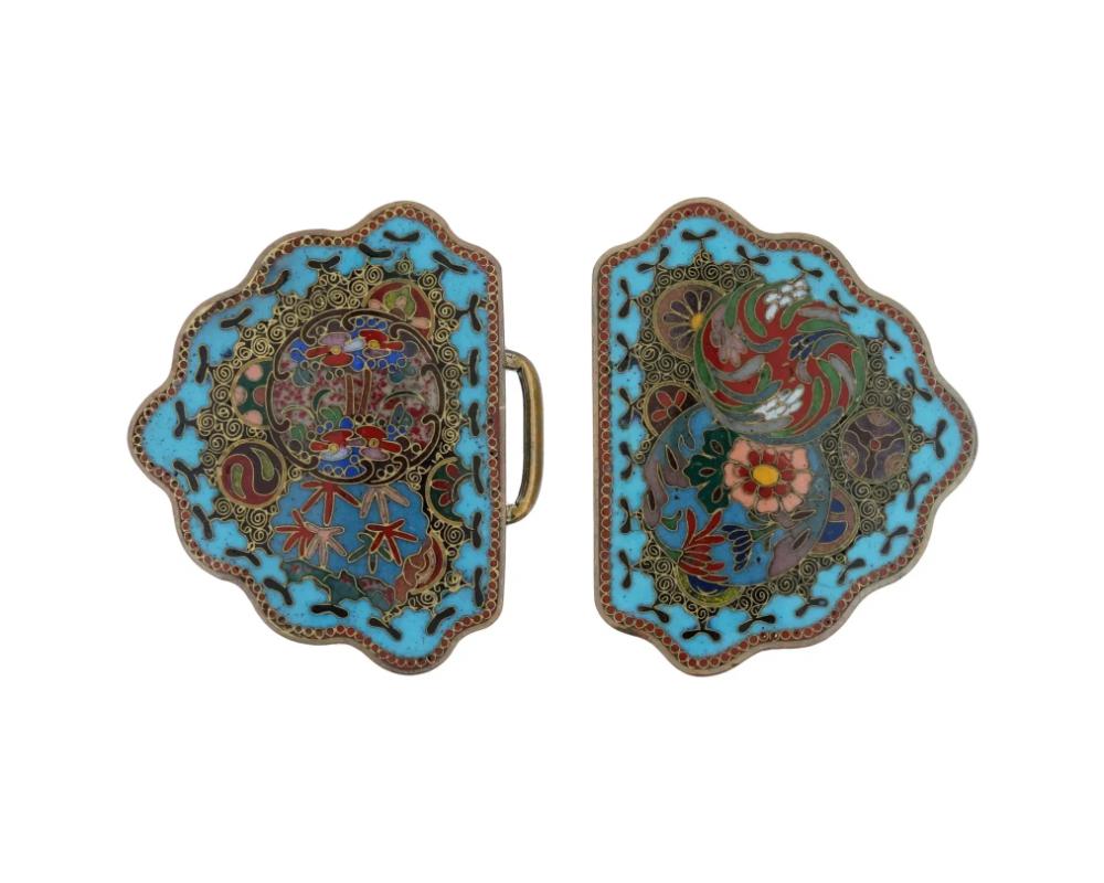 An antique Japanese, late Meiji era, enamel over copper belt buckle. The ware consists of two parts with a clasp. The belt buckle is covered with polychrome enamel medallions representing floral, foliage and swirl motifs surrounded by a geometrical