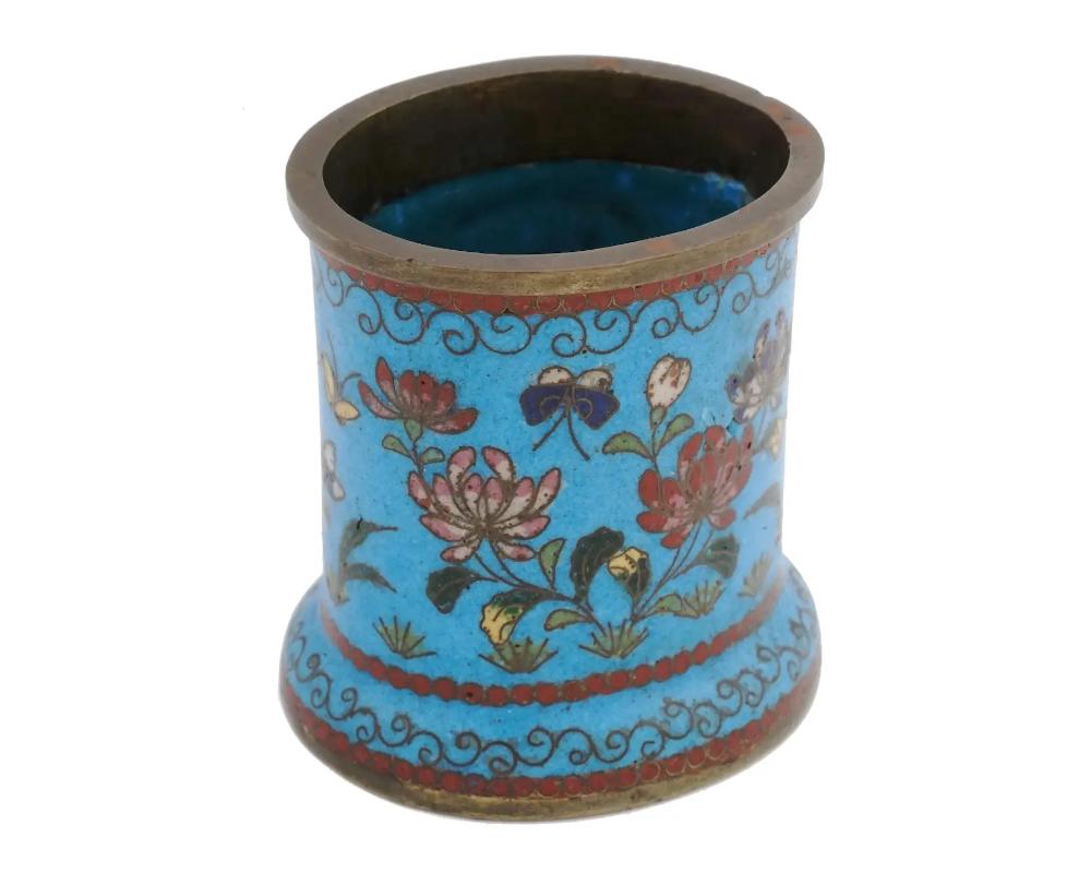 An antique Japanese copper brush pot with cloisonne enamel design. Late Meiji era, before 1912. Cylinder shape with oval base. The item is decorated with depictions of flowers and butterflies against the turquoise background. Oriental Decor For