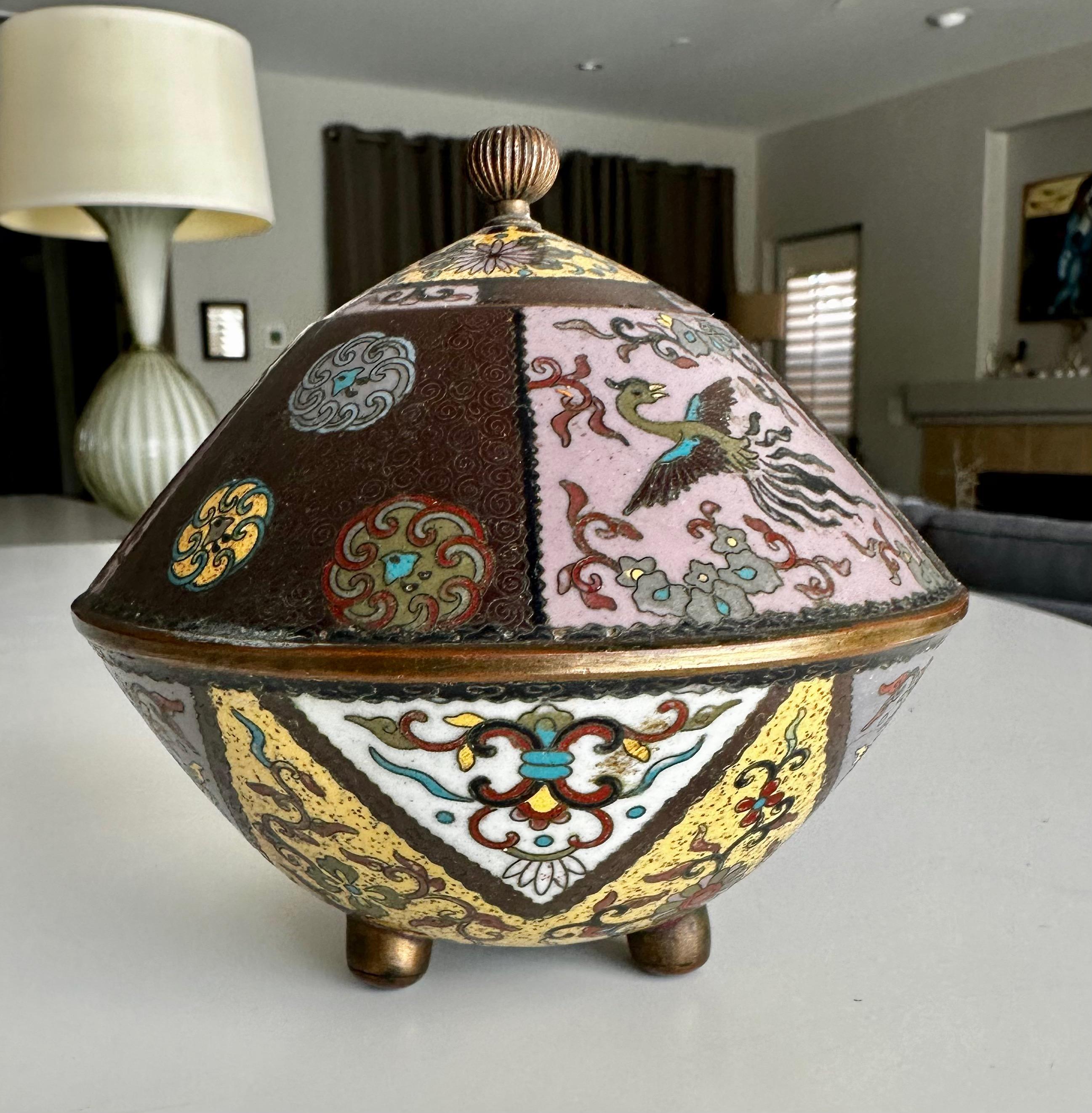 Antique Japanese Meiji period cloisonne enamel lidded koro incense burner standing on brass footed base. Embellished with stylized phoenix birds, geometrical ornaments, along with floral and foliage motifs throughout.. 