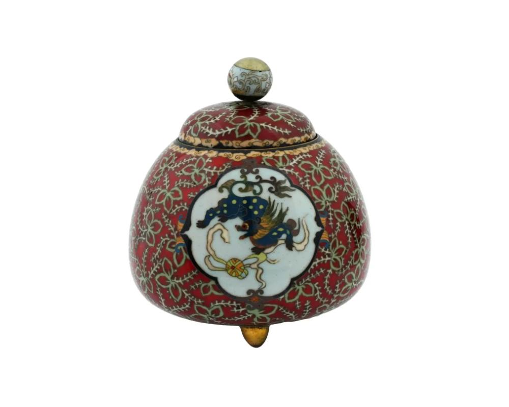 Antiguo tarro japonés de cobre con tapa y diseño de esmalte cloisonné policromado. Finales del periodo Meiji, antes de 1912. Forma redonda, tapa con remate de globo. La pieza descansa sobre tres pies. Color de fondo rojo. Motivo del dragón.