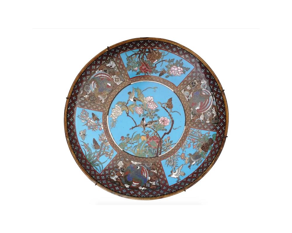 A fine quality antique Japanese Meiji era enamel plate,

The central medallion depicts a scene with birds and butterflies sitting on a blooming branch.

The central part is surrounded by six medallions depicting picturesque scenes with partridge