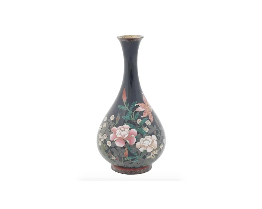 An antique Japanese cloisonne vase from the Meiji period featuring an elegant onion shape with a long neck and a saturated black enamel. Depicts multicolored floral and foliate images to the body. The outer borders are decorated with stylized floral