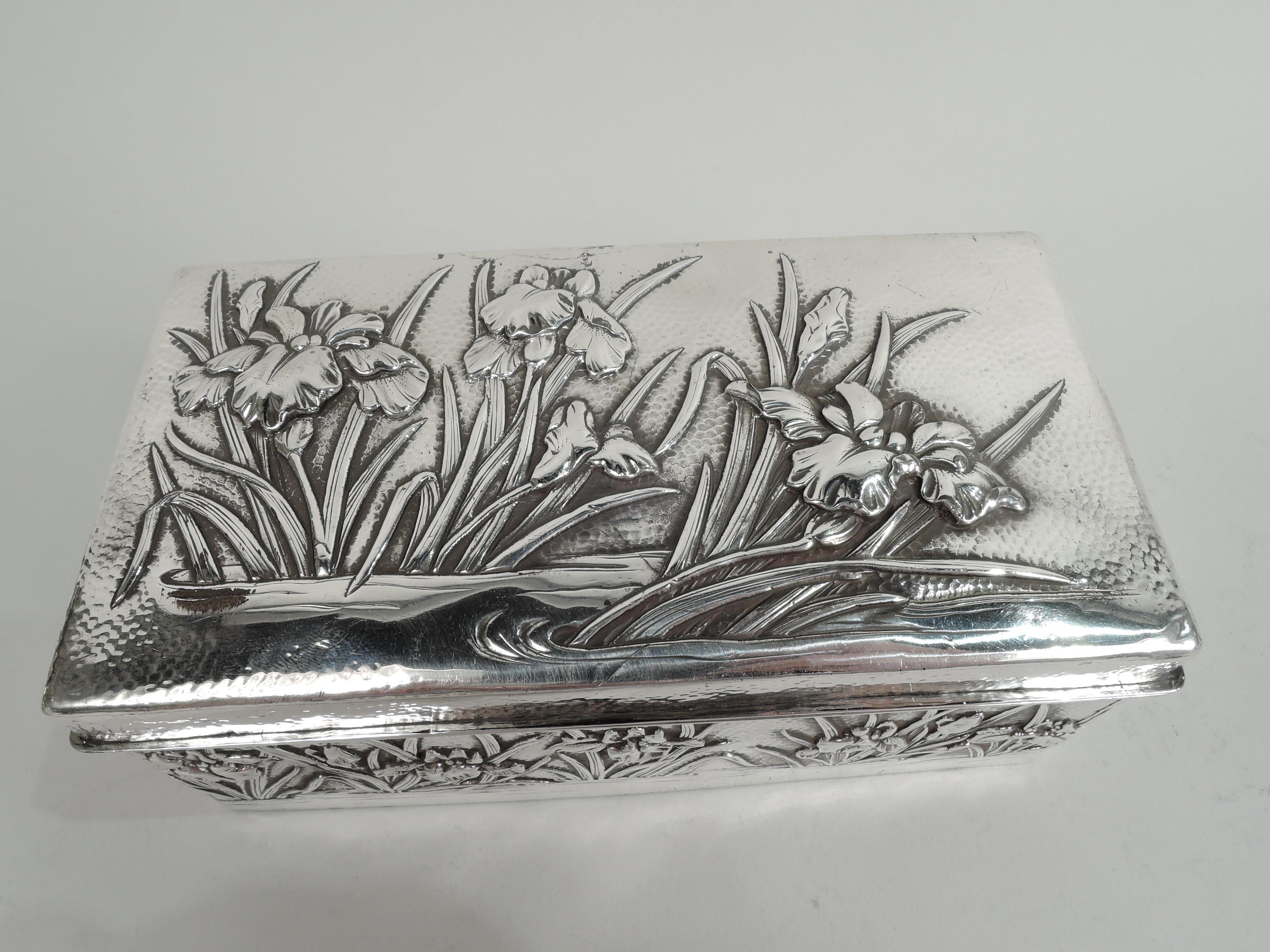 Japanese silver box, ca 1890. Rectangular with straight sides and hinged cover. On cover top and box sides are chased and engraved iris flowers and tendrils in eddying water. Stippled ground. Box and cover interior lined with stained wood. Open