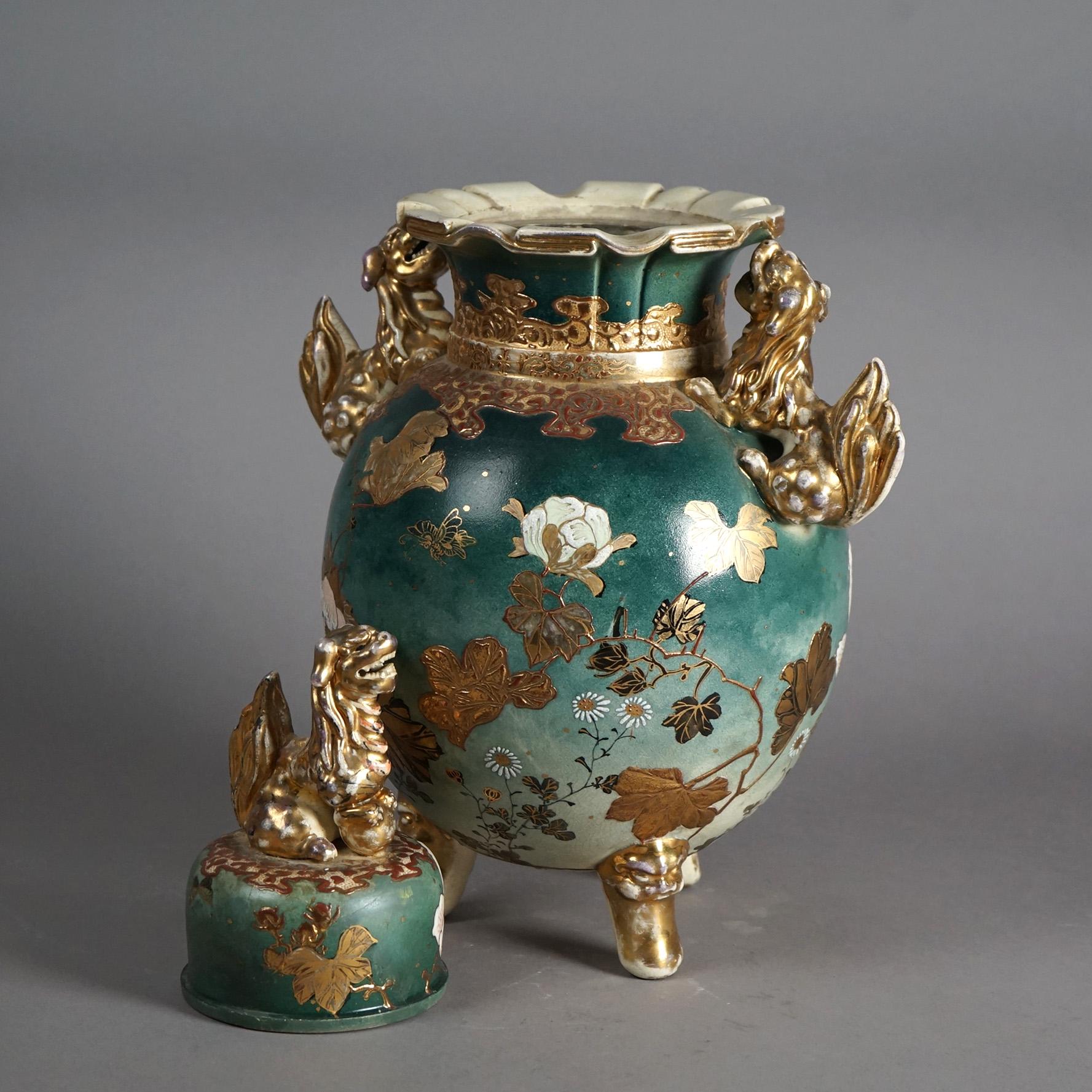 An antique Japanese Meiji figural urn offers porcelain construction with foo dog lid and handles on bulbous vessel having garden scene, raised on figural feet, signed as photographed, c1910

Measures- 19.5''H x 12.5''W x 8.5''D