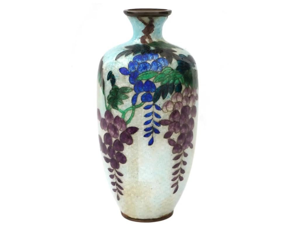 An antique Japanese, late Meiji era, Ginbari enamel over copper vase. The urn shaped vase is enameled with a polychrome image of blossoming Wisteria flowers on the light blue ground made in the Ginbari Cloisonne technique. Ginbari is a Japanese