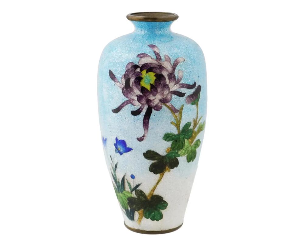 An antique Japanese, late Meiji era, Ginbari enamel over copper vase. The urn shaped vase is enameled with a polychrome image of blossoming flowers on the light blue ground made in the Ginbari Cloisonne technique. Ginbari is a Japanese cloisonne